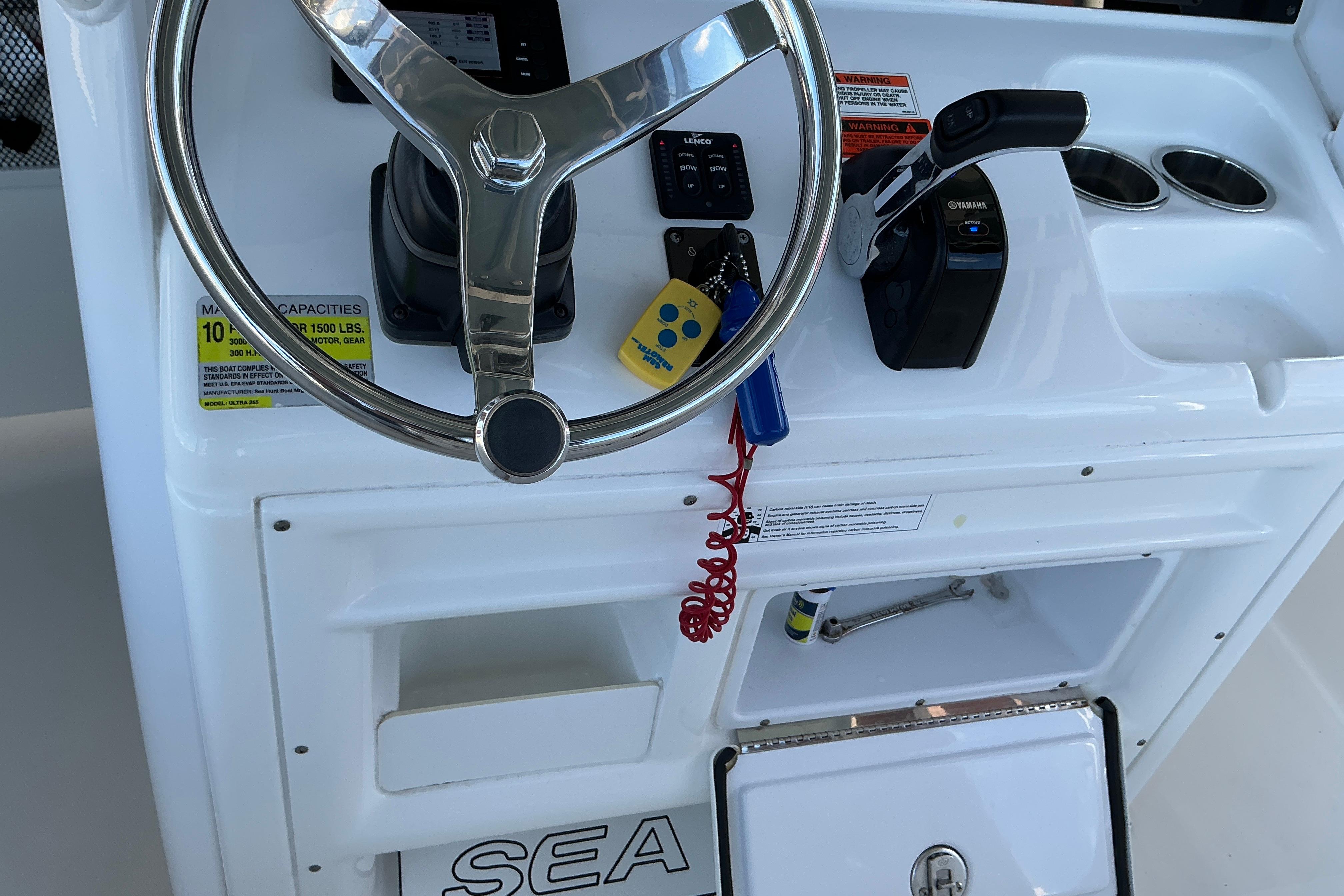 Steering console of a 2019 Sea Hunt Ultra 255 SE boat with controls and storage.