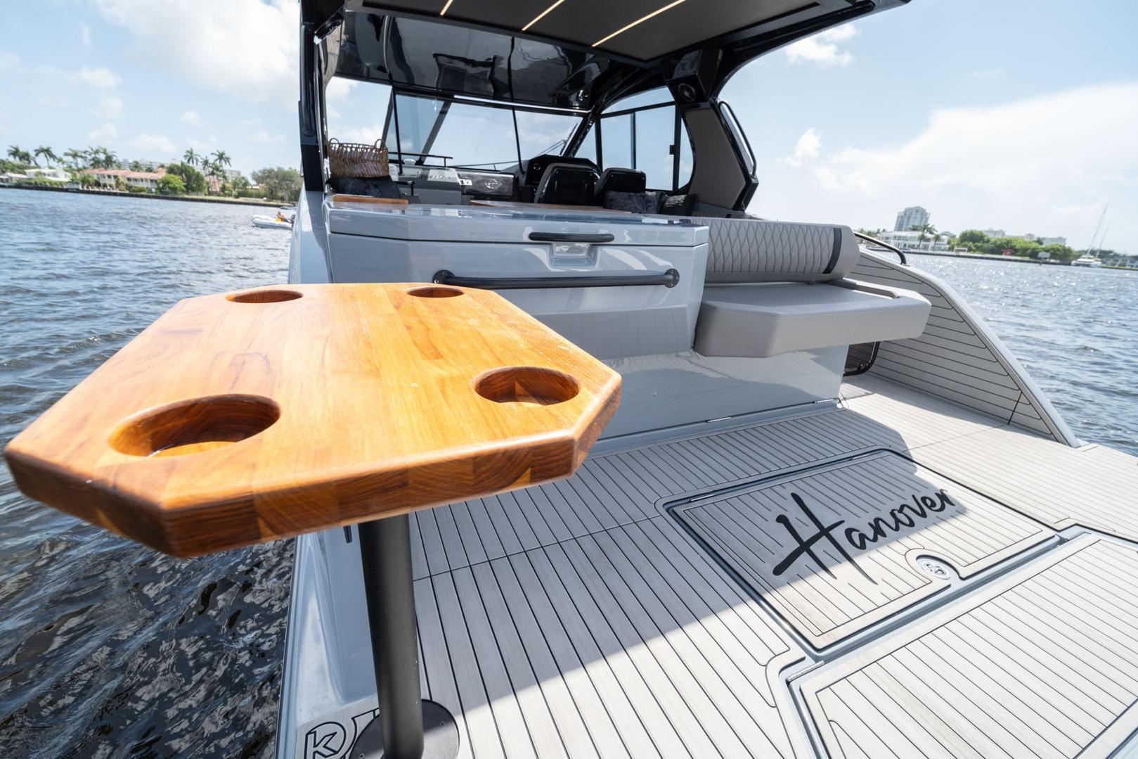 Luxury Hanover 387 yacht deck with wooden table, 2026 model, on serene water.