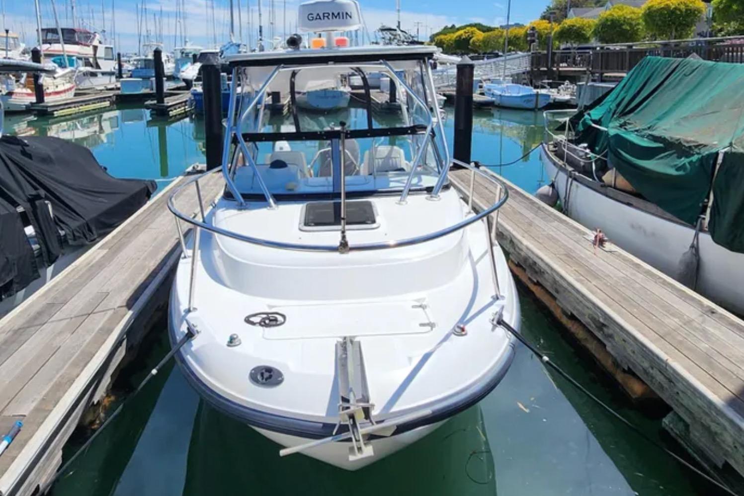 Boston Whaler 21 Conquest 2000 docked at marina, surrounded by boats and clear water.