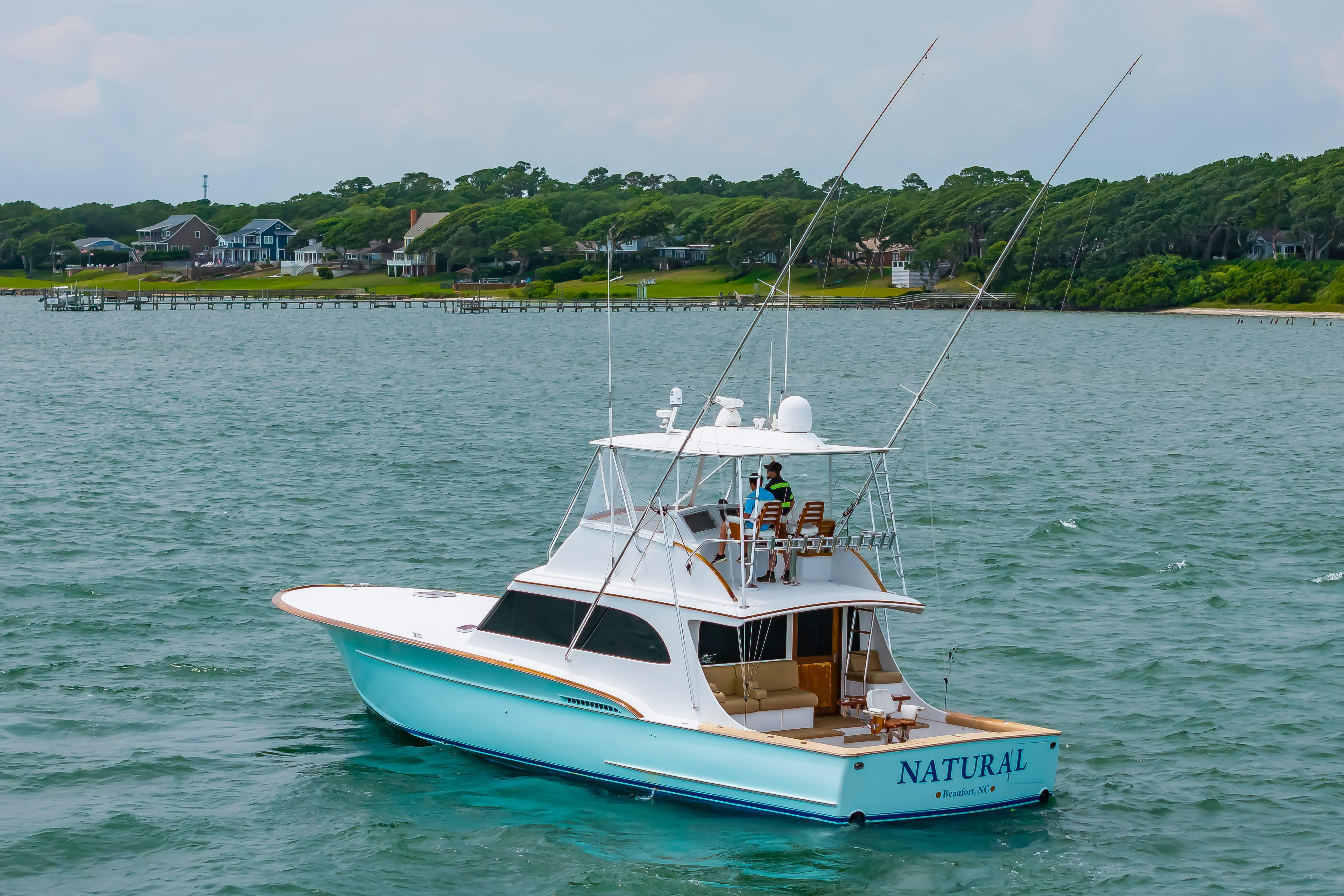 Custom Carolina Scarborough 56 Convertible yacht, 1993, cruising near a scenic shoreline.