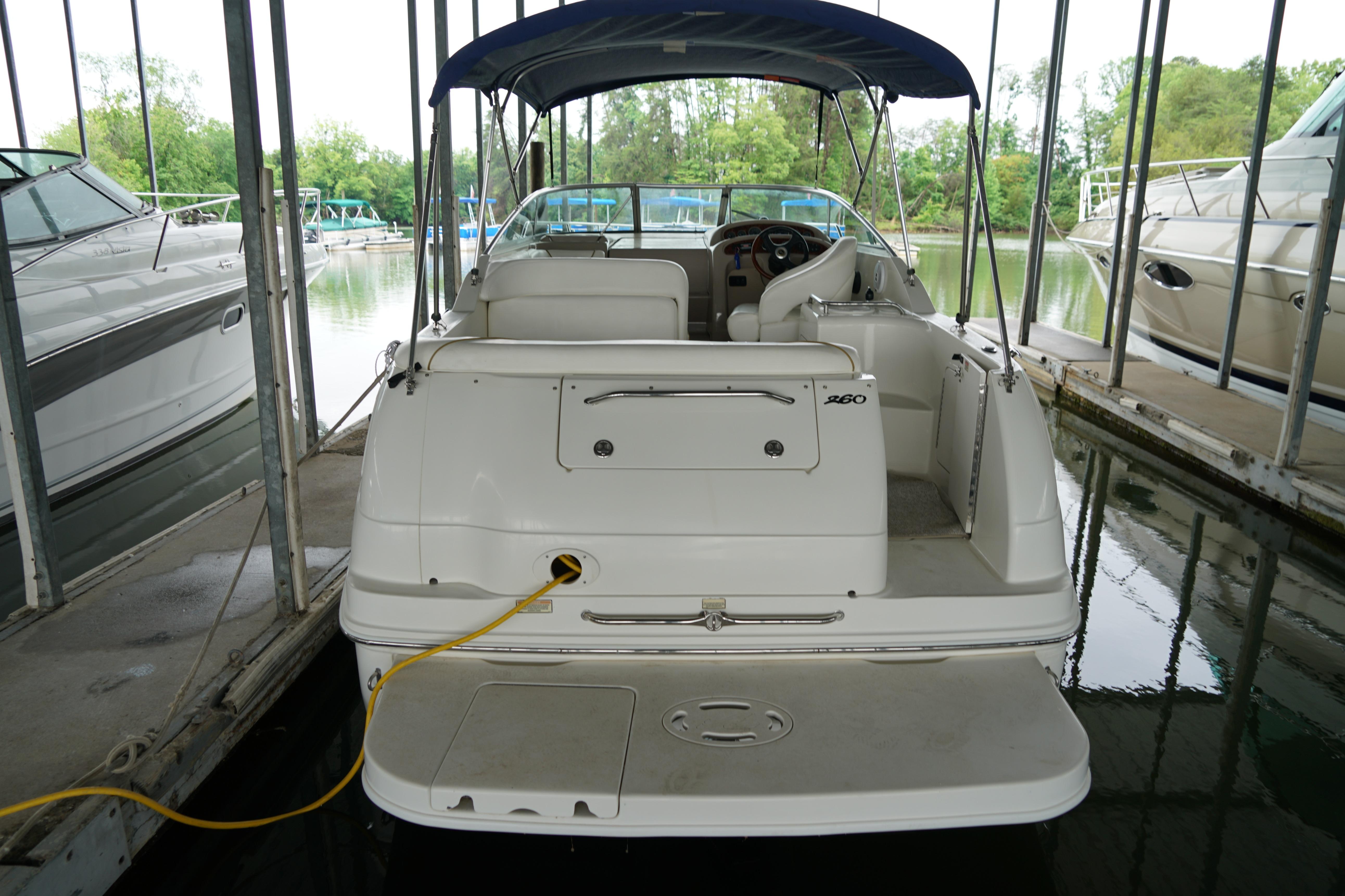2002 Sea Ray Sundancer 260 docked in a marina, rear view with canopy.