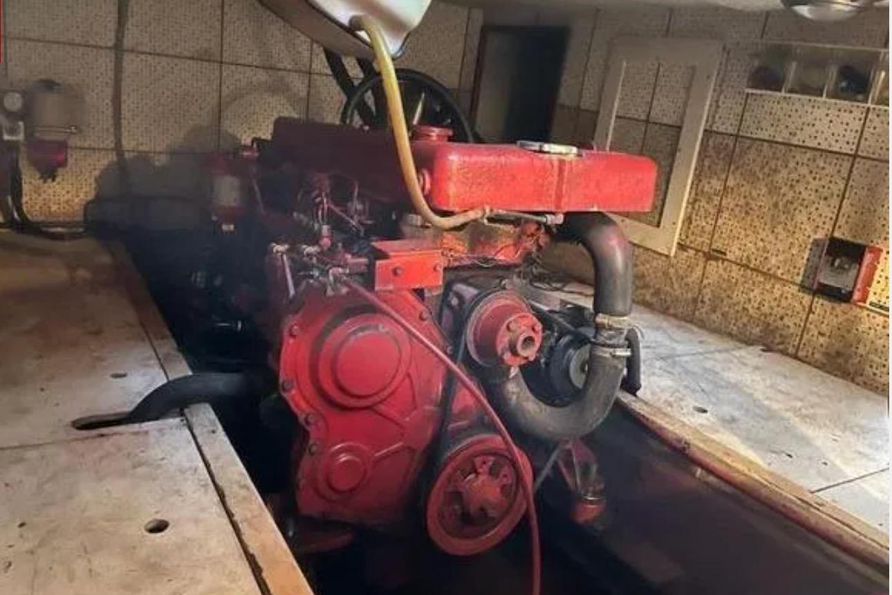 Engine room of 1981 Marine Trader TRUNK CABIN with visible red engine components.