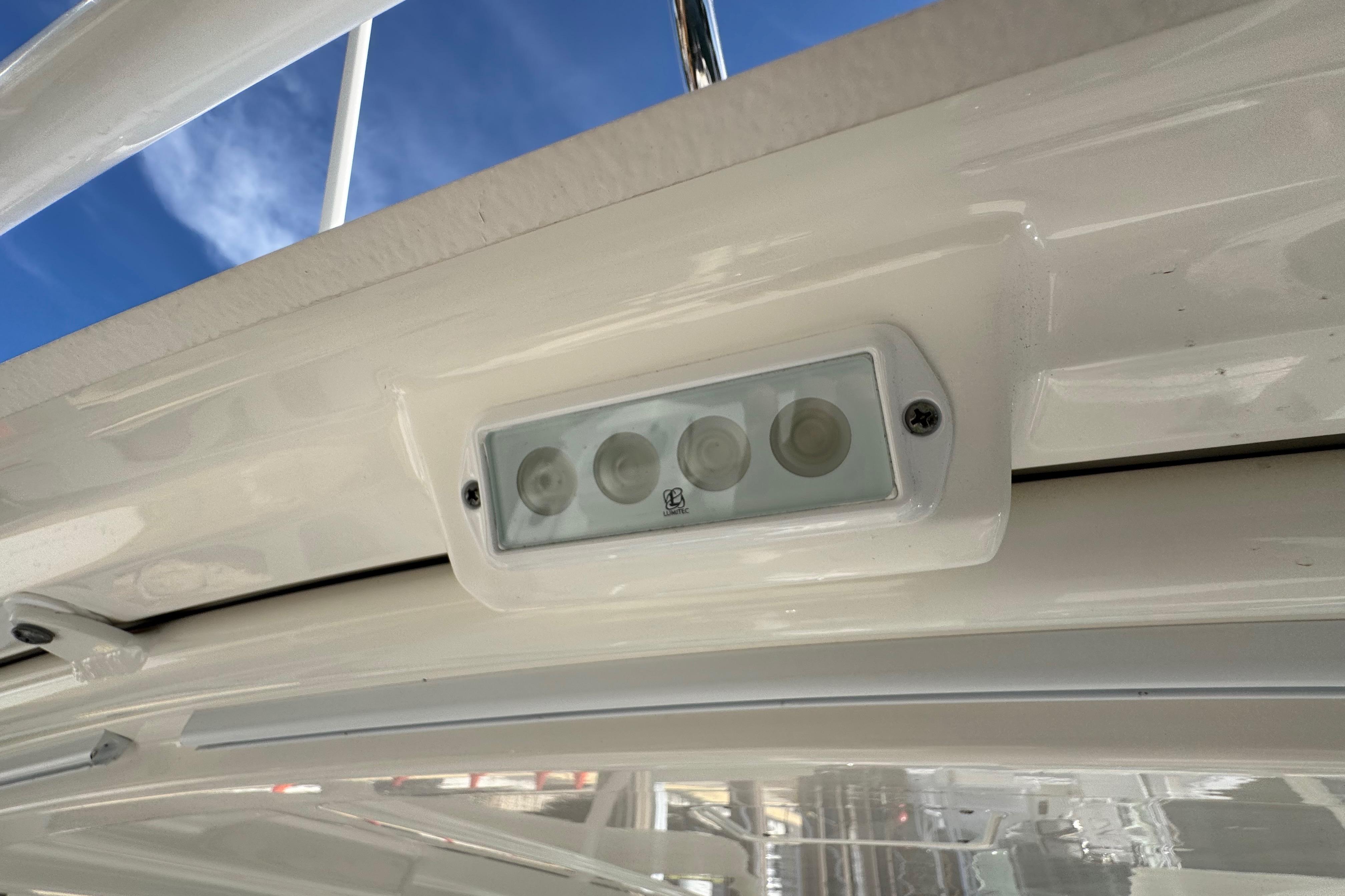LED light fixture on 2022 Pursuit DC 266 Dual Console boat, under clear blue sky.
