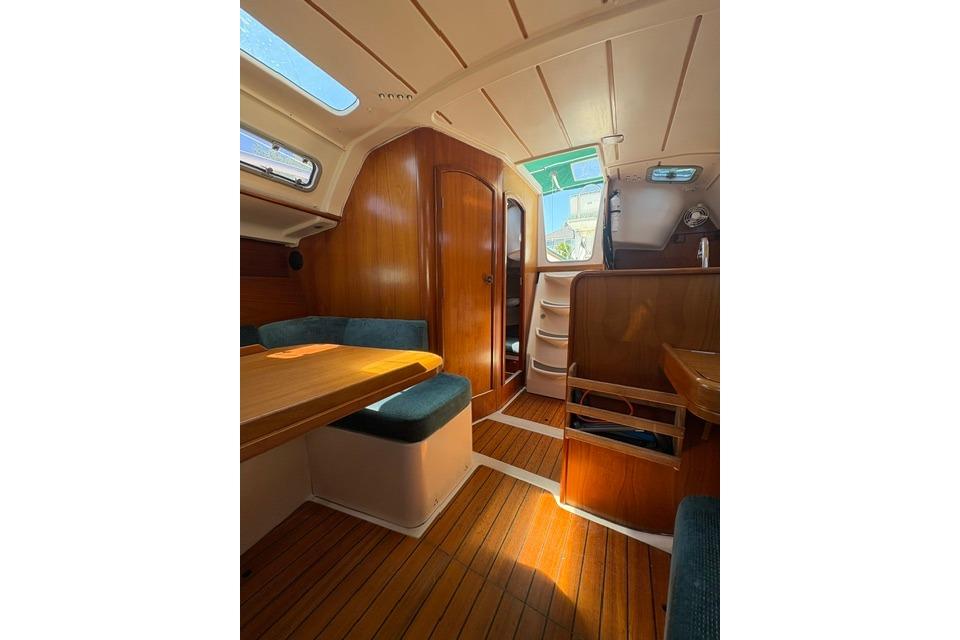 Interior of 2000 Beneteau Oceanis 321 sailboat with wooden finishes and seating area.