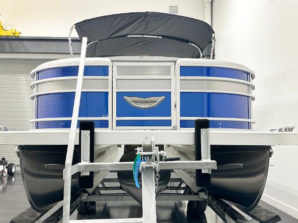 2025 Bennington 23LFBCSR pontoon boat in showroom, featuring blue and silver design.