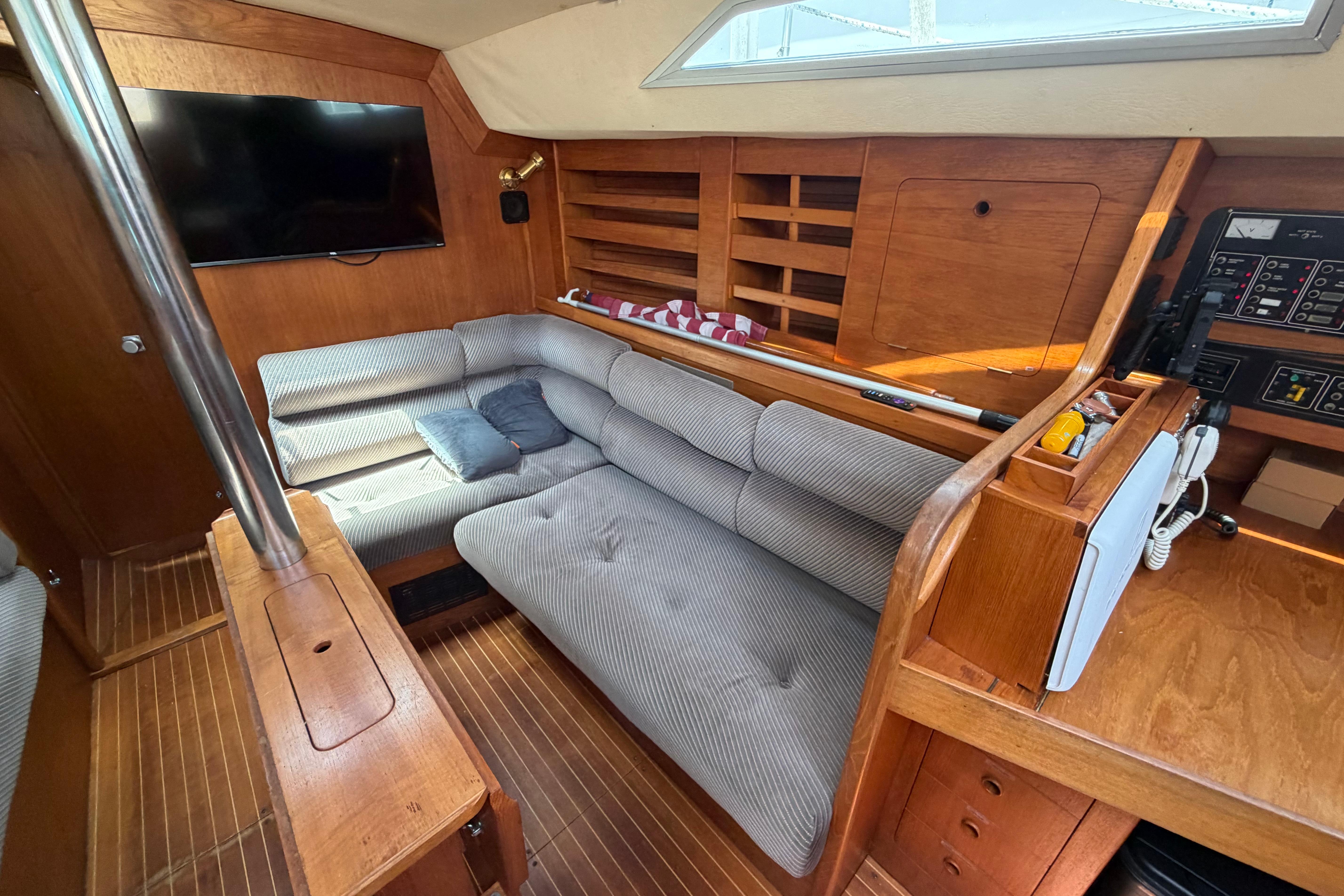 Interior of 1987 Moody 376 yacht with cozy seating and wooden cabinetry.