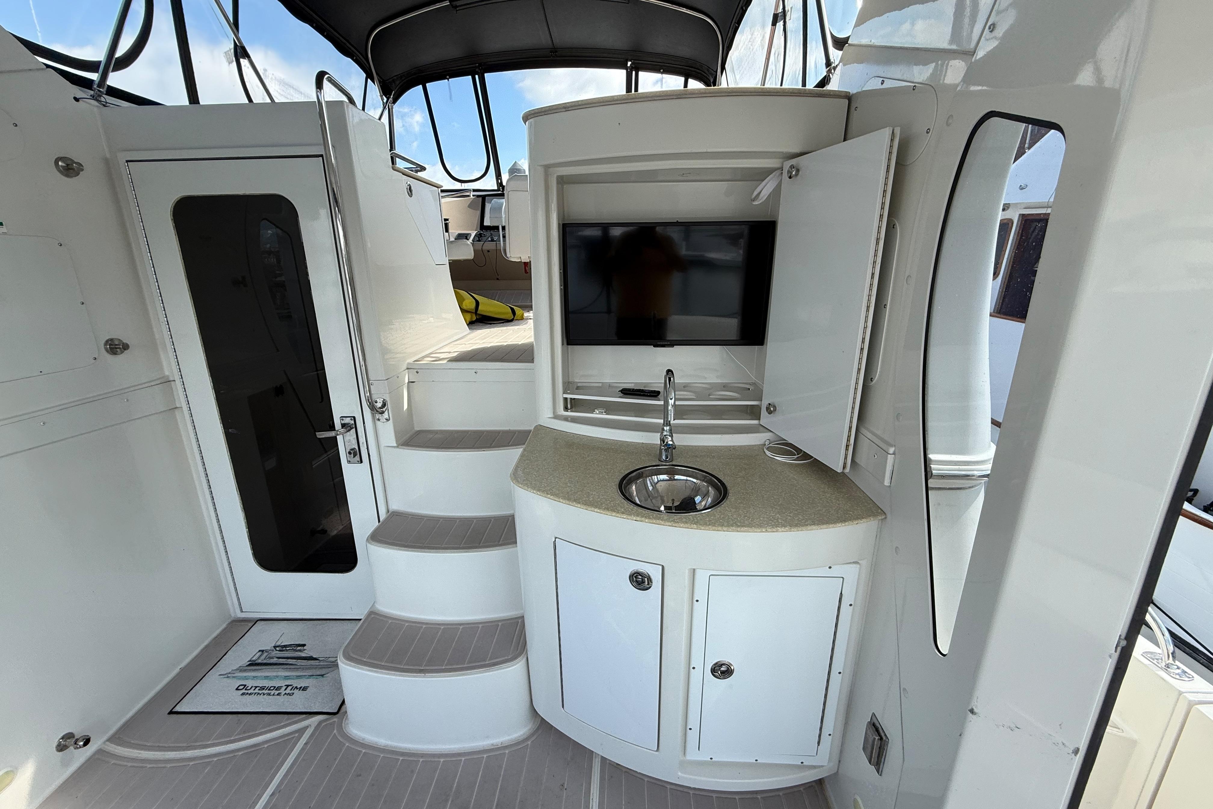 2006 Carver 43 Motor Yacht interior with stairs, sink, and TV.