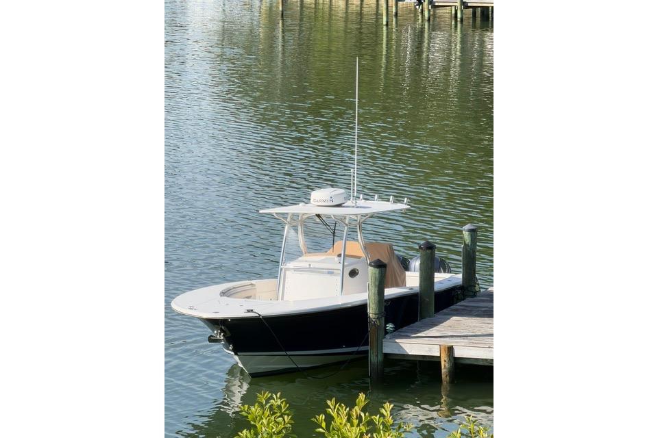 2014 Southport 29 FE boat docked on calm water near a wooden pier.