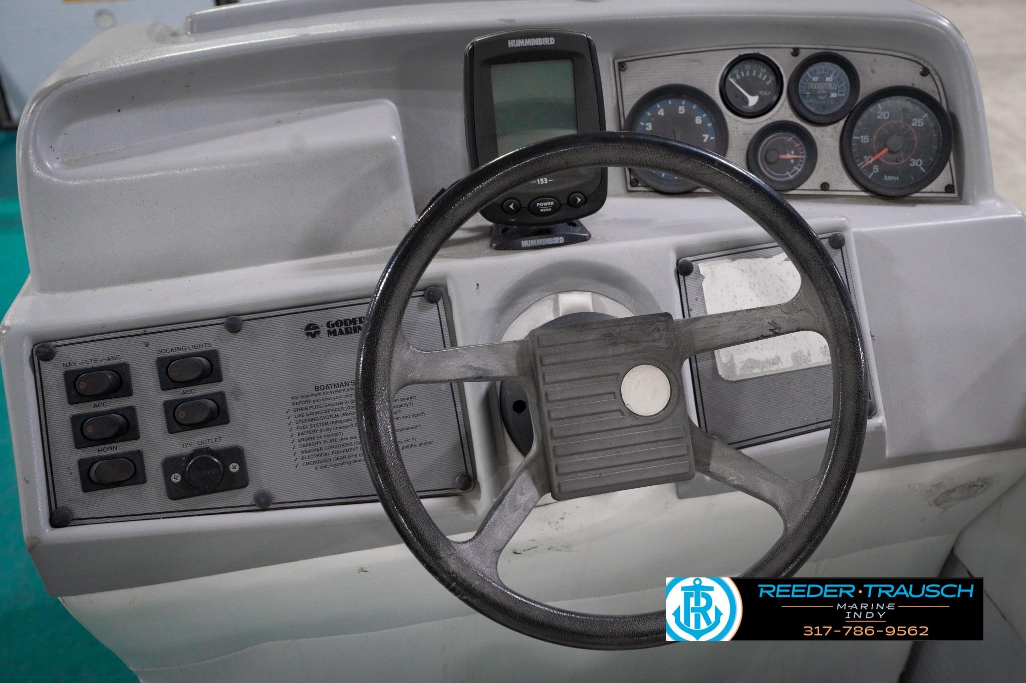 1992 Godfrey Sweetwater boat dashboard with steering wheel and control panel.