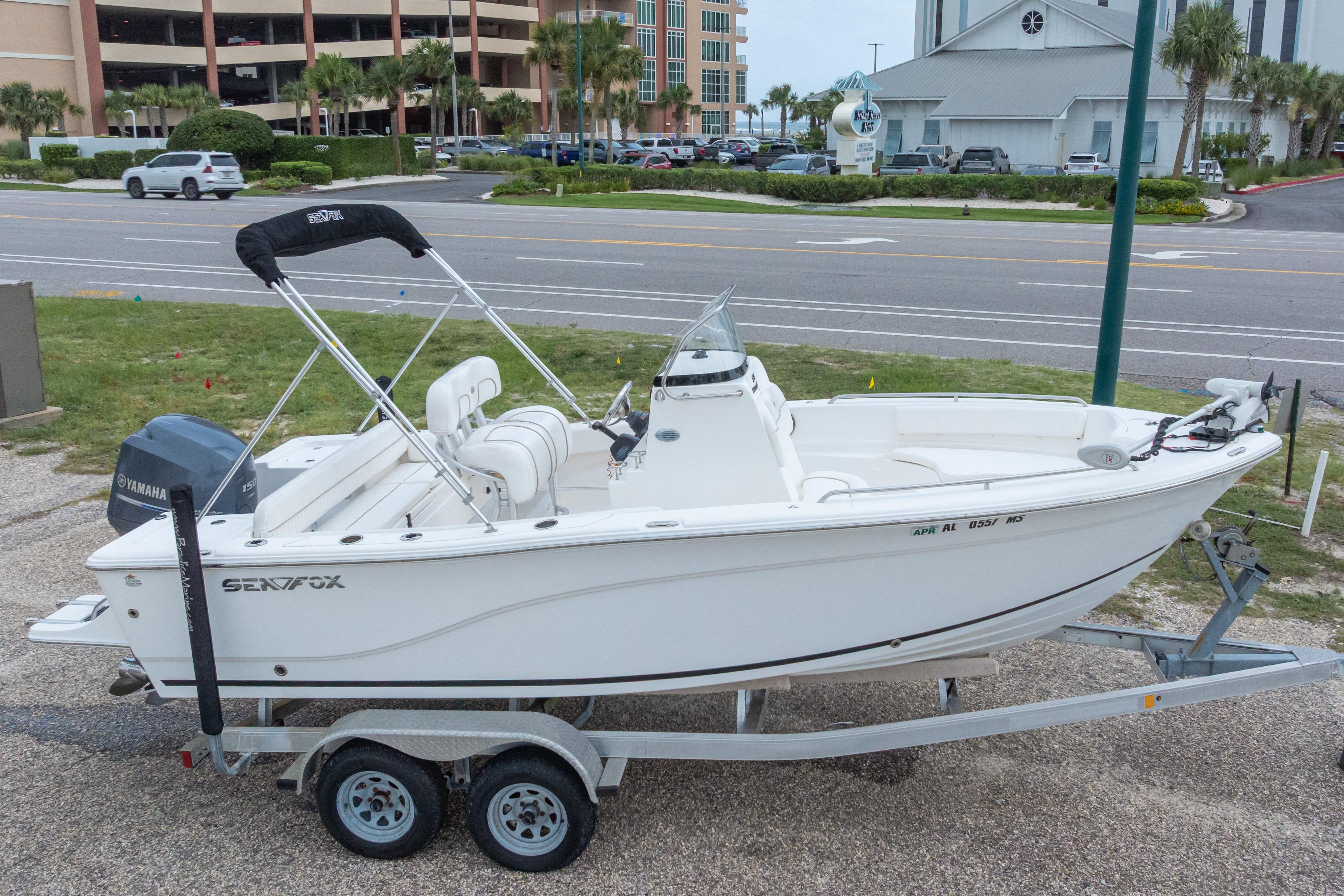 2014 Sea Fox 209 Commander boat on trailer, parked near a road.