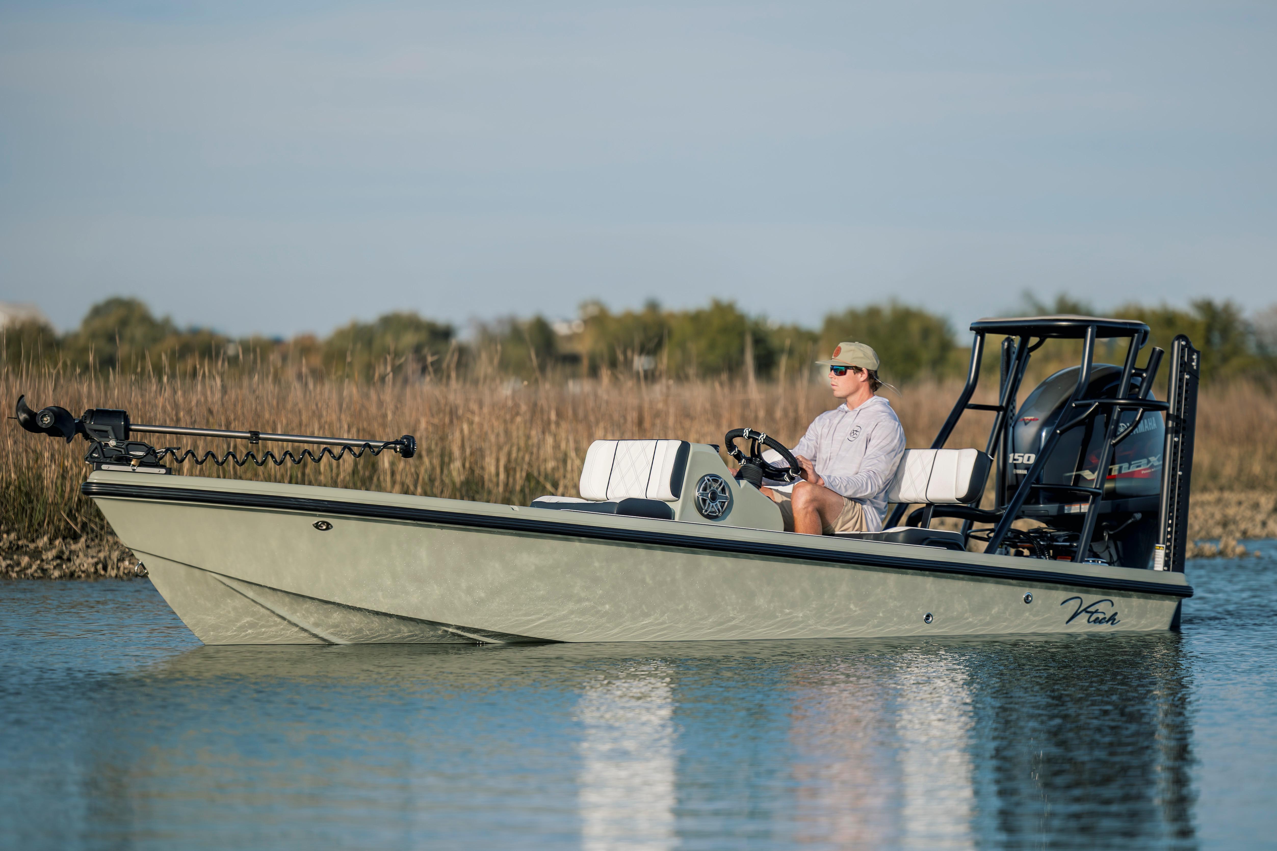 2025 Vtech 18 boat on calm water, person steering, natural background.