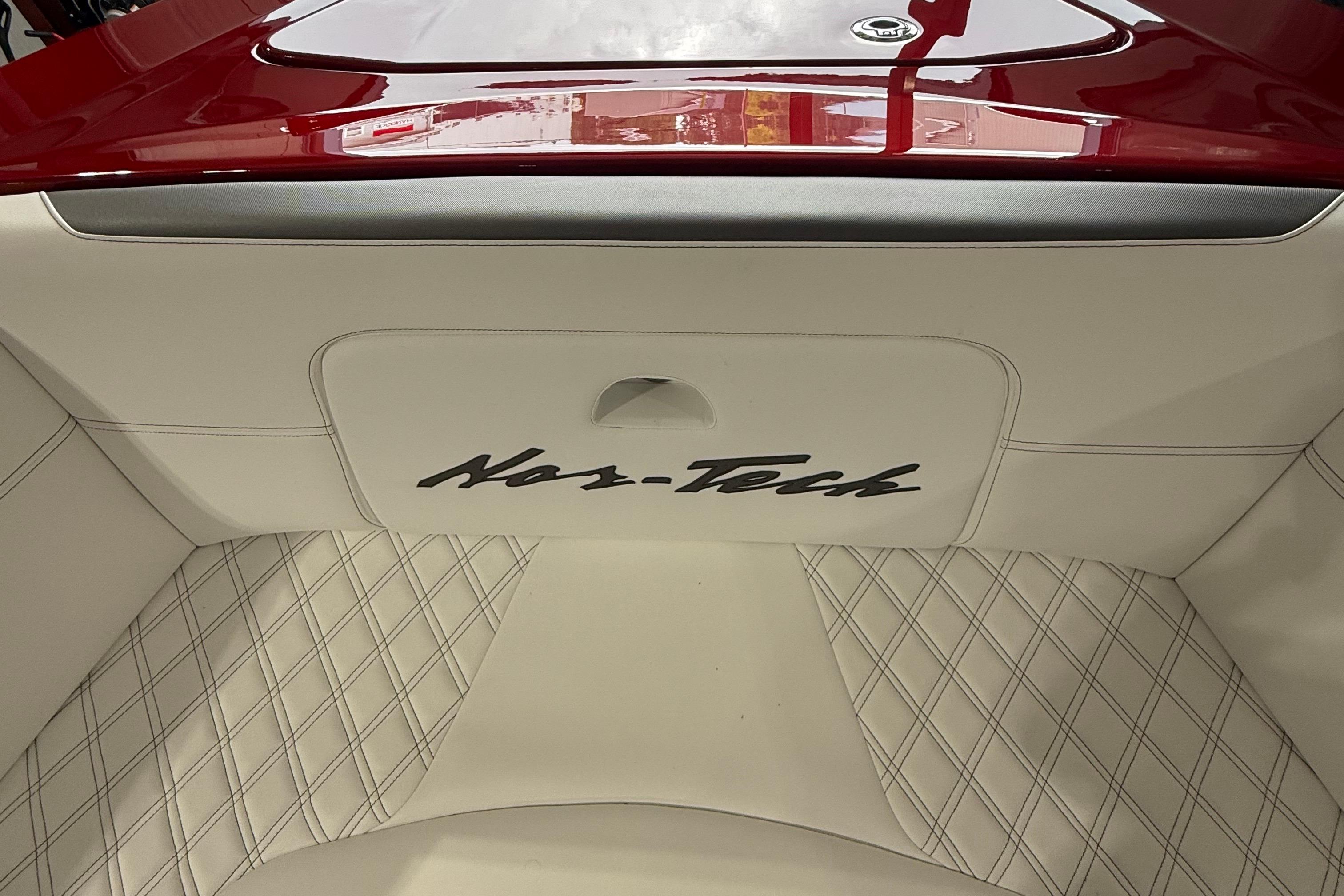 2025 Nor-Tech 390 Sport boat interior with white diamond-stitched upholstery and red accents.
