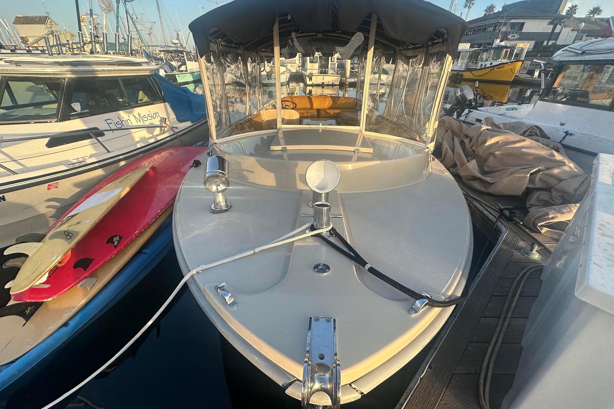 2007 Duffy 22 Electric boat docked, surrounded by other boats and surfboards.