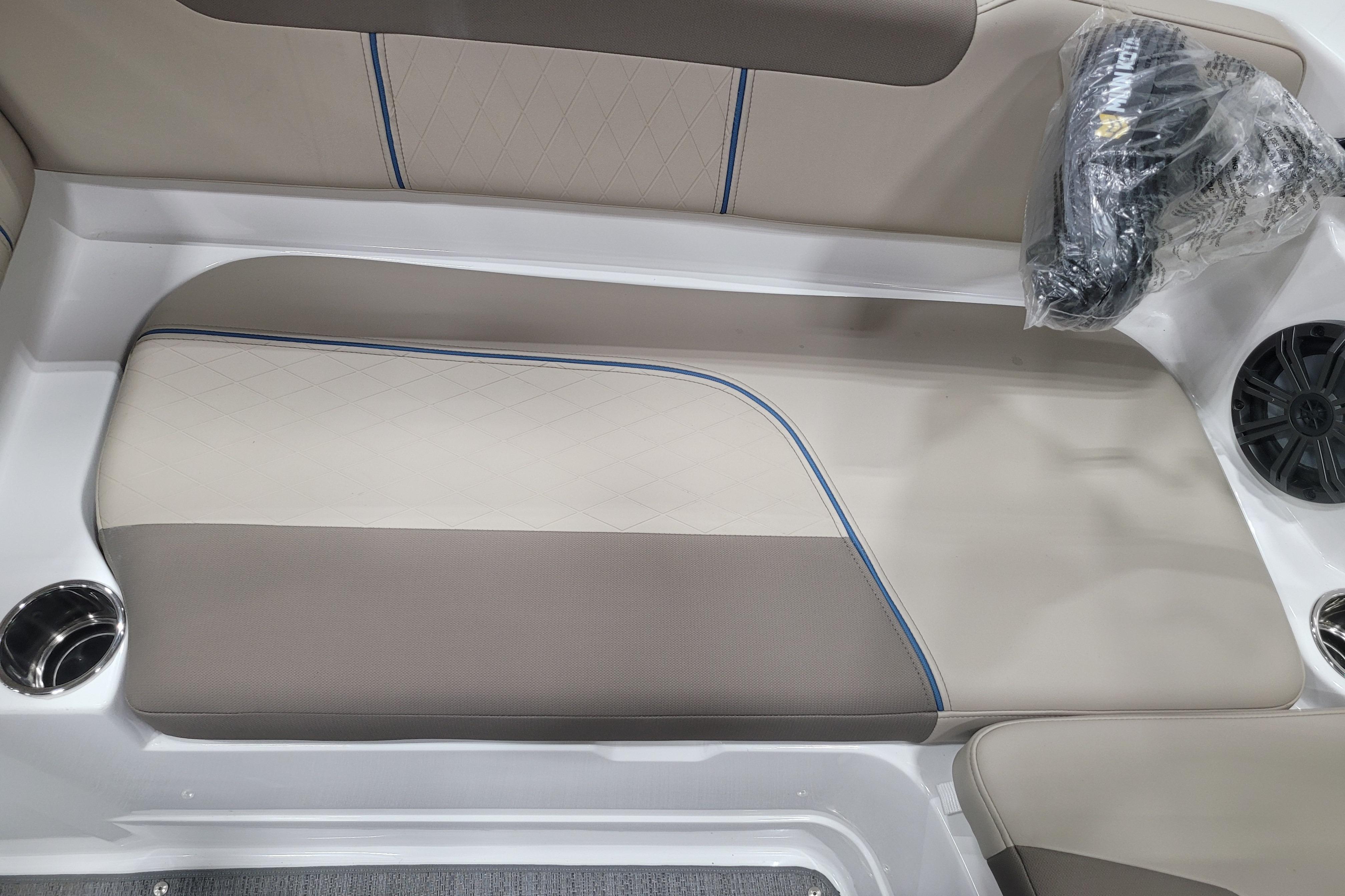 2026 Tahoe 2150 boat interior with beige and gray seating, cup holders, and speaker.