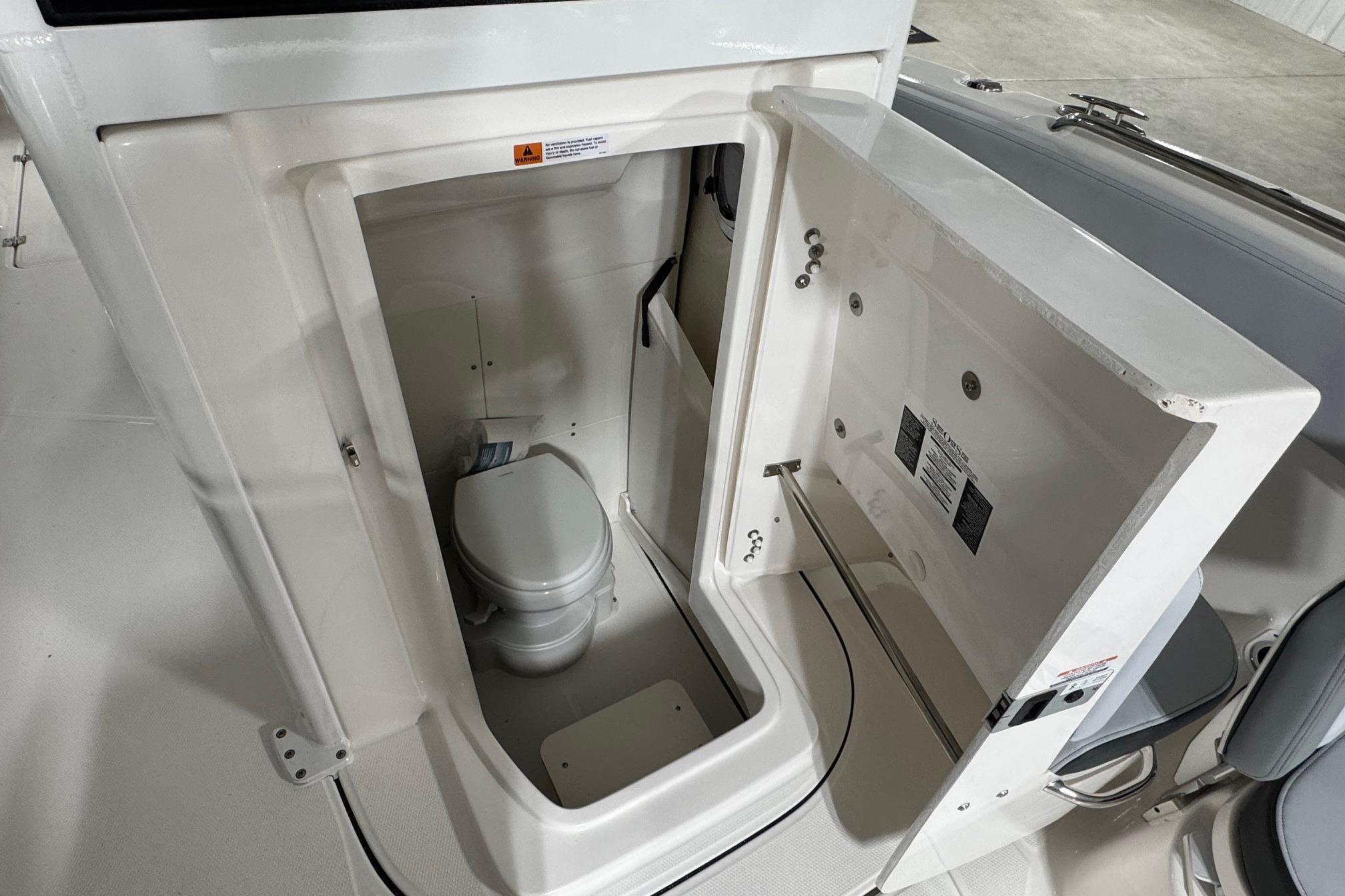 2025 Robalo R360 Center Console boat interior with compact marine toilet.