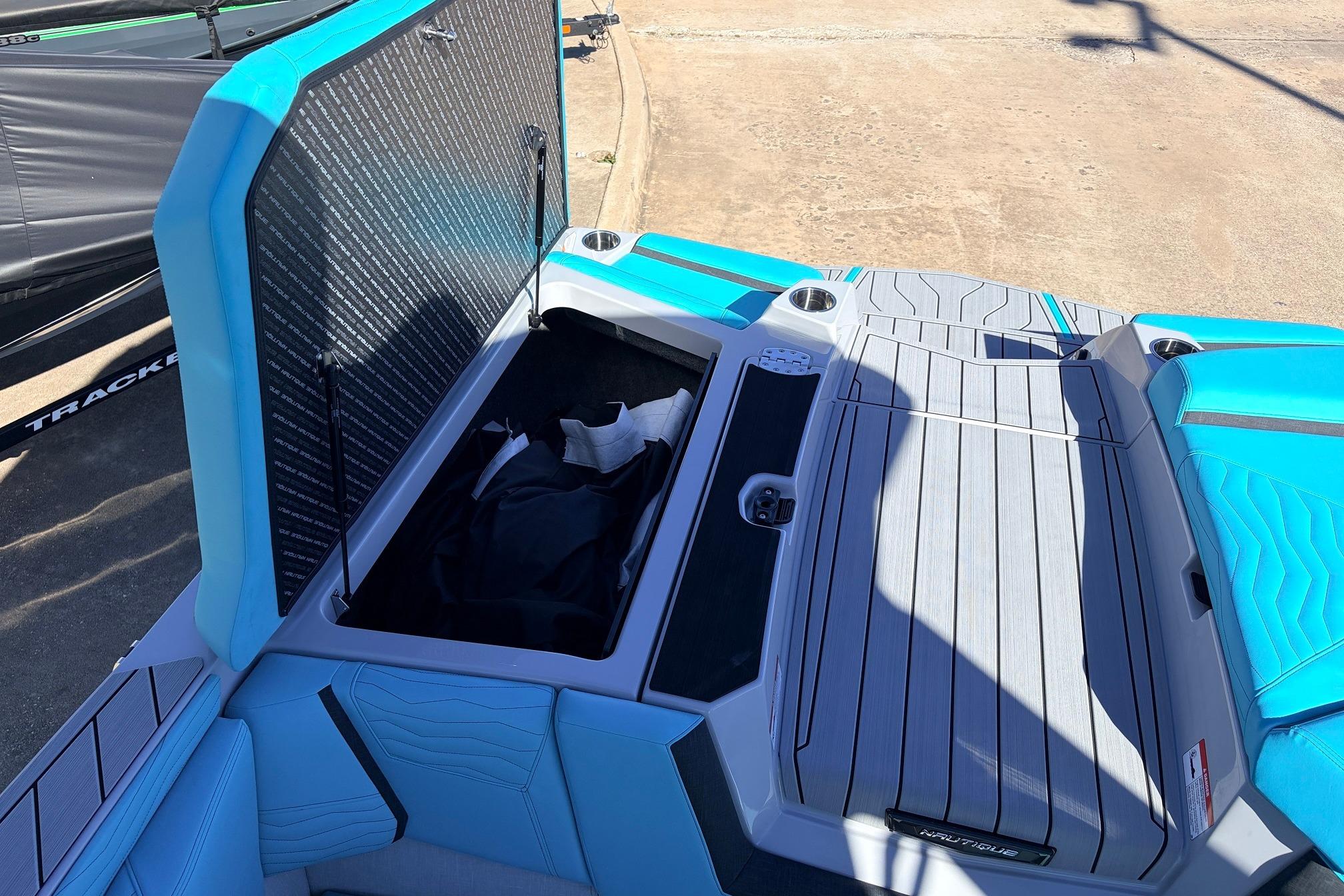 2026 Nautique Super Air Nautique G23 boat storage compartment with open hatch, blue and gray interior.