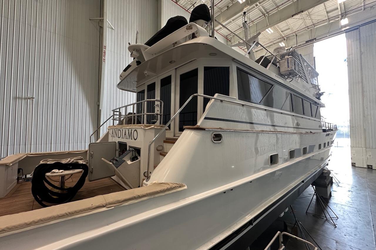 Luxury yacht Broward 102, 1991 model, docked in a spacious indoor marina.