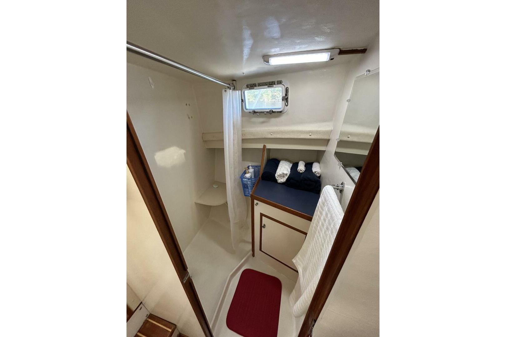 1997 Rosborough Trawler bathroom with shower, storage, and porthole window.