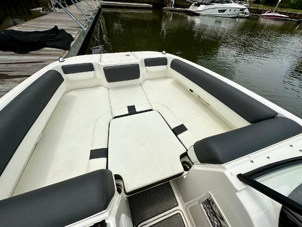 Bayliner DX 2050 boat interior, 2022 model, featuring spacious seating and sleek design at a dock.