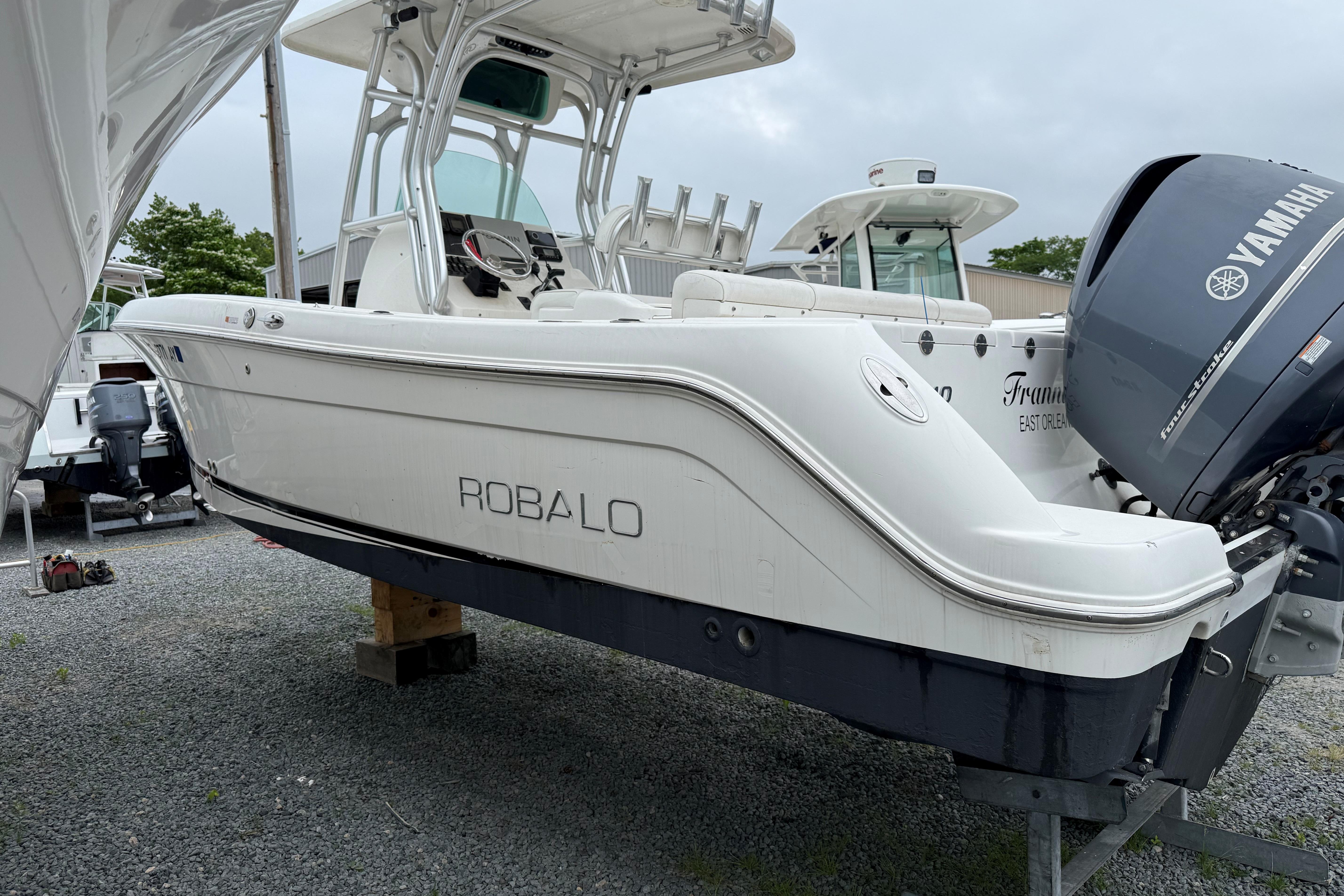 2009 Robalo R240 Center Console boat with Yamaha engine, displayed on gravel lot.