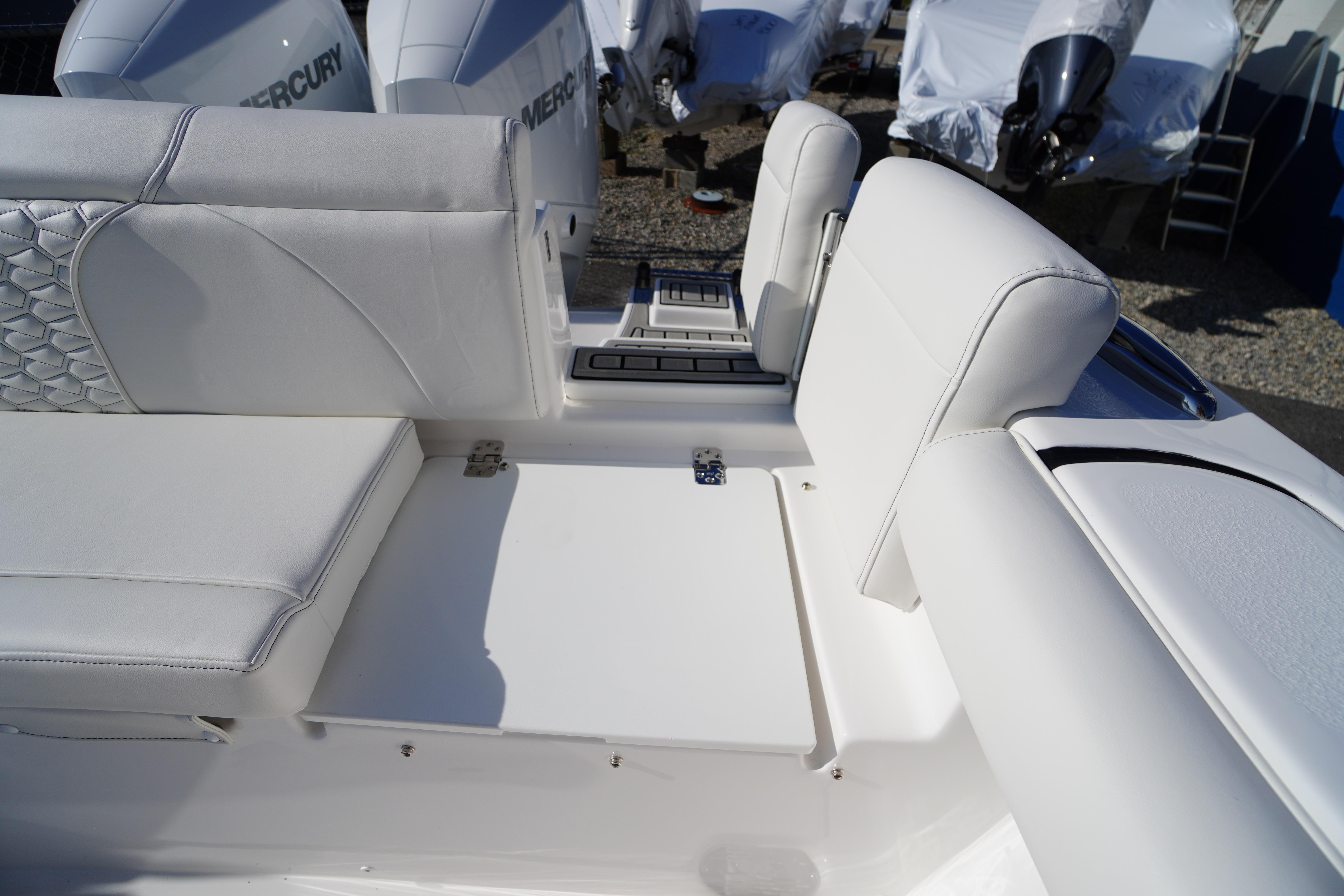 2026 Tidewater 272 LXF boat interior with white cushioned seating and Mercury engines.