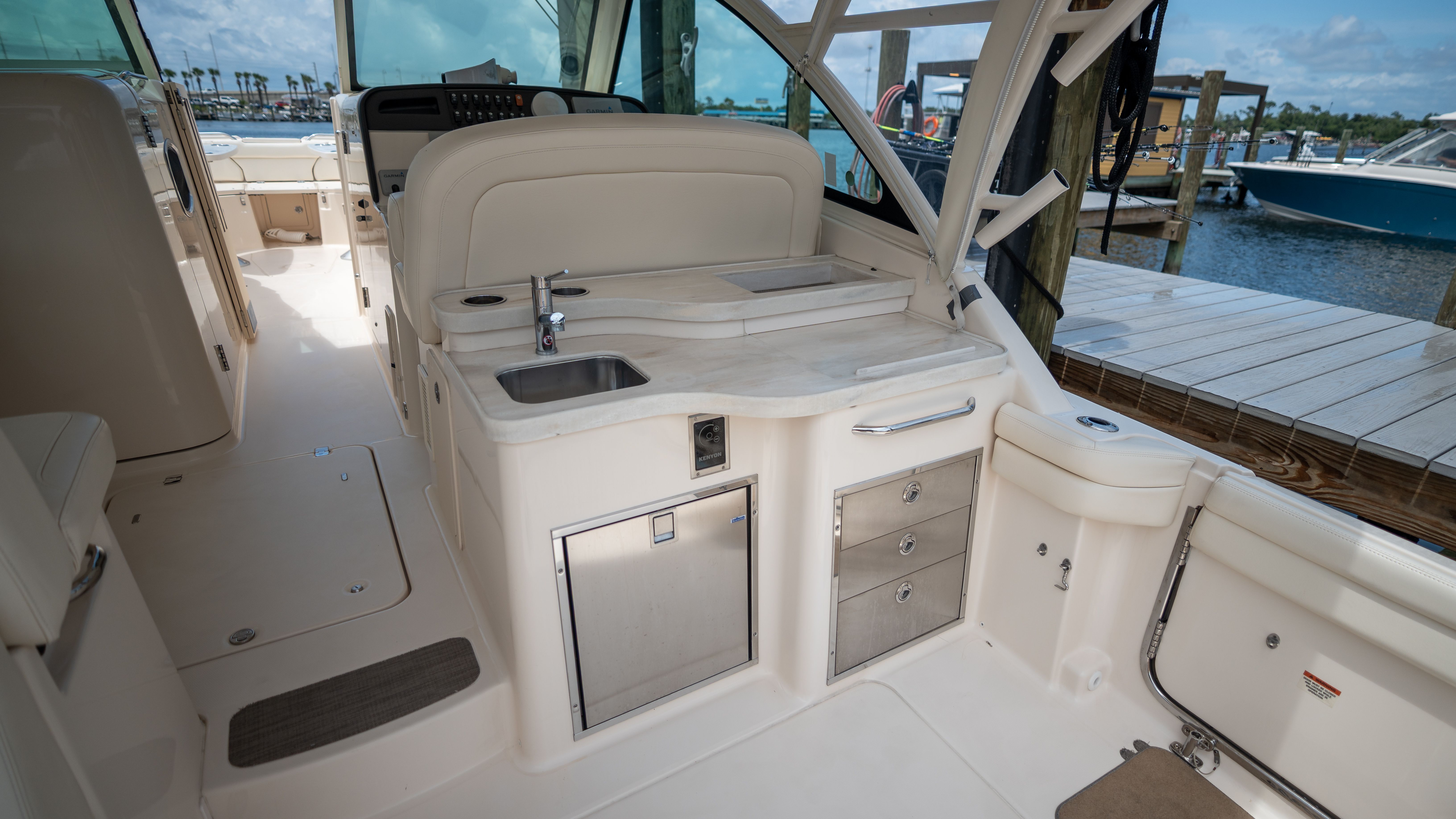 2019 Grady-White 375 Freedom: Luxurious cockpit with sink, storage, and marina view.