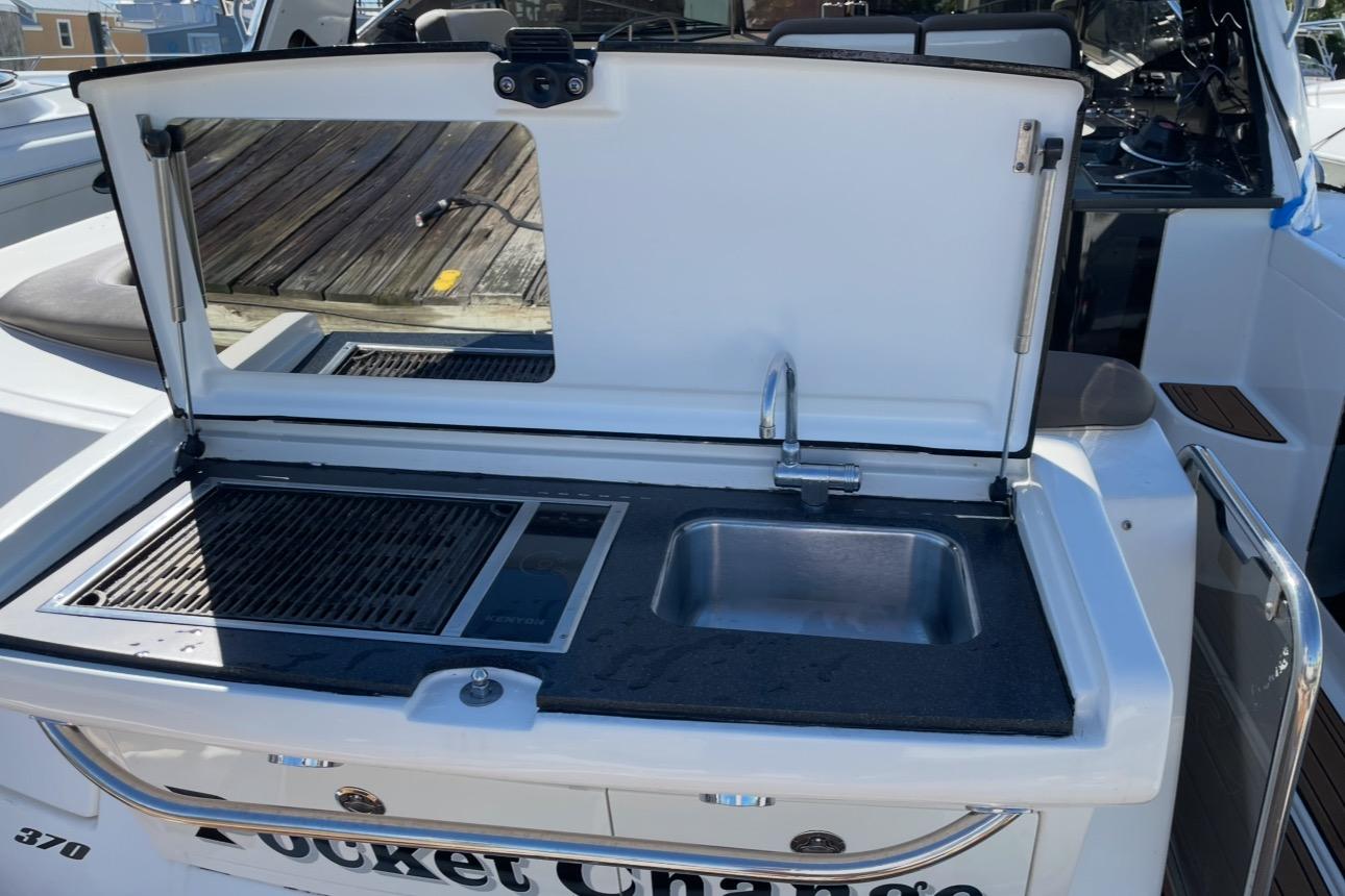 Outdoor kitchenette on a 2016 Searay Sundancer 370 yacht with sink and grill.