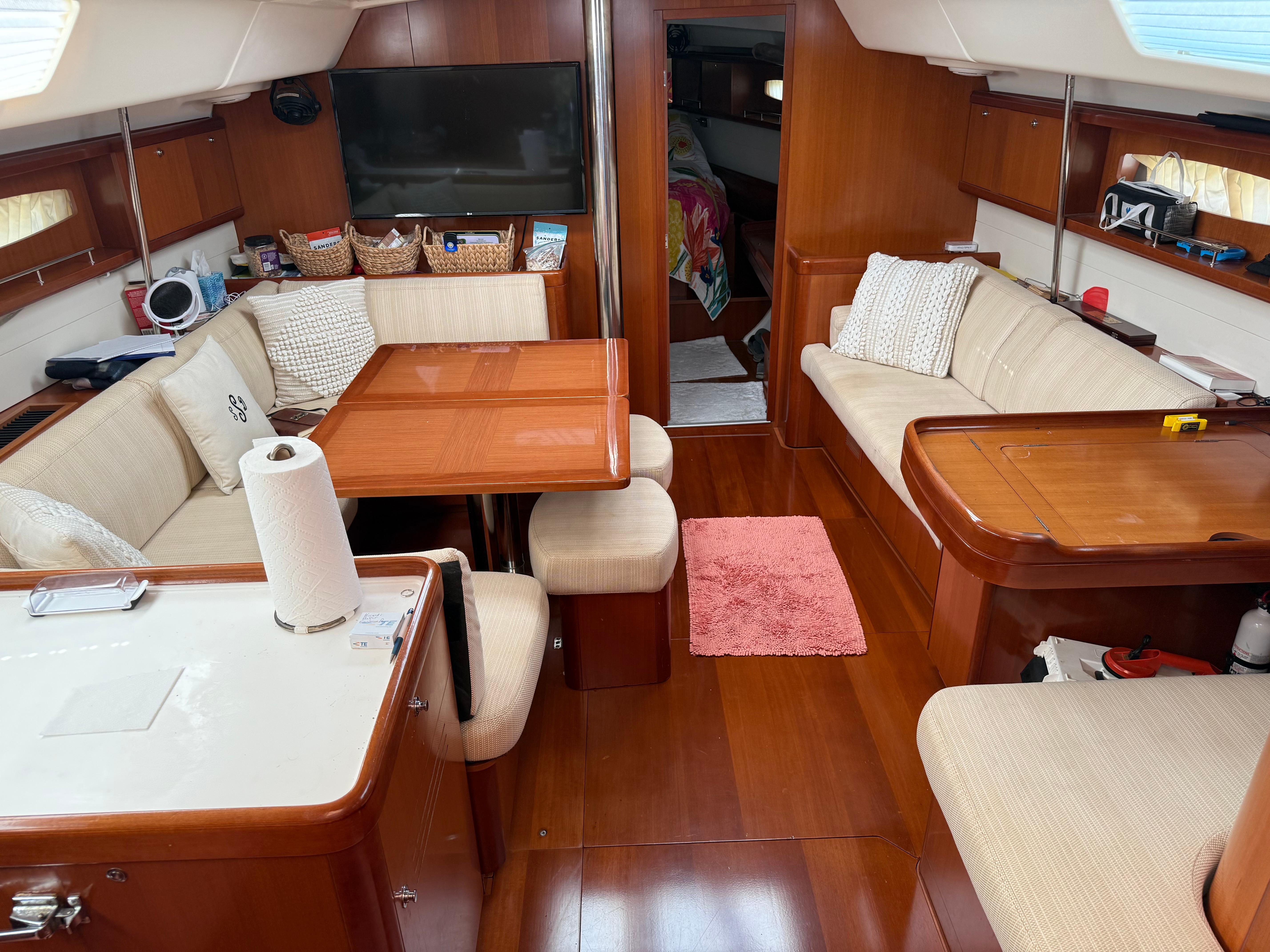 Interior of a 2007 Beneteau 49 yacht with cozy seating and wooden finishes.