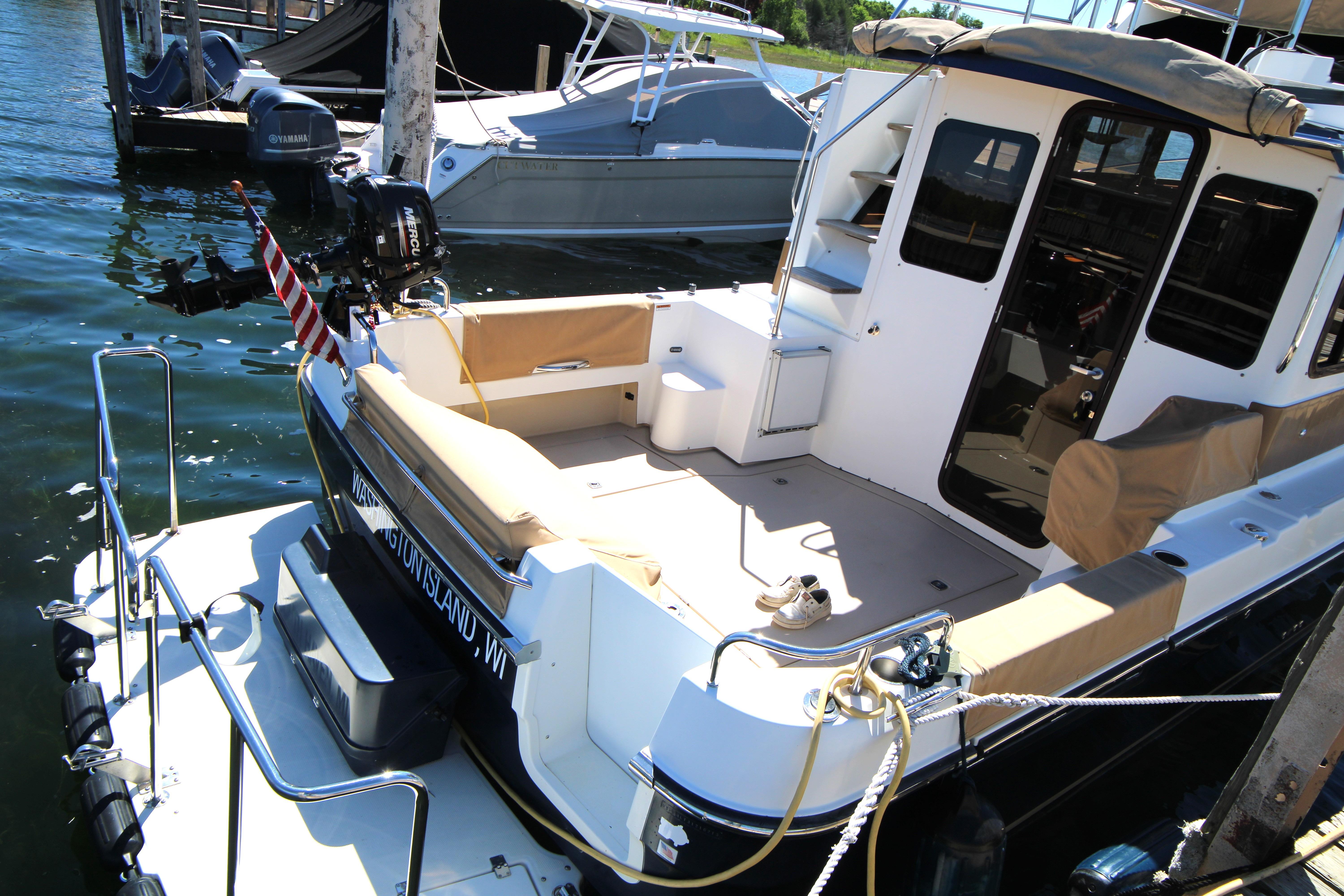 2013 Ranger Tugs R-31 CB docked, featuring spacious deck and seating area.