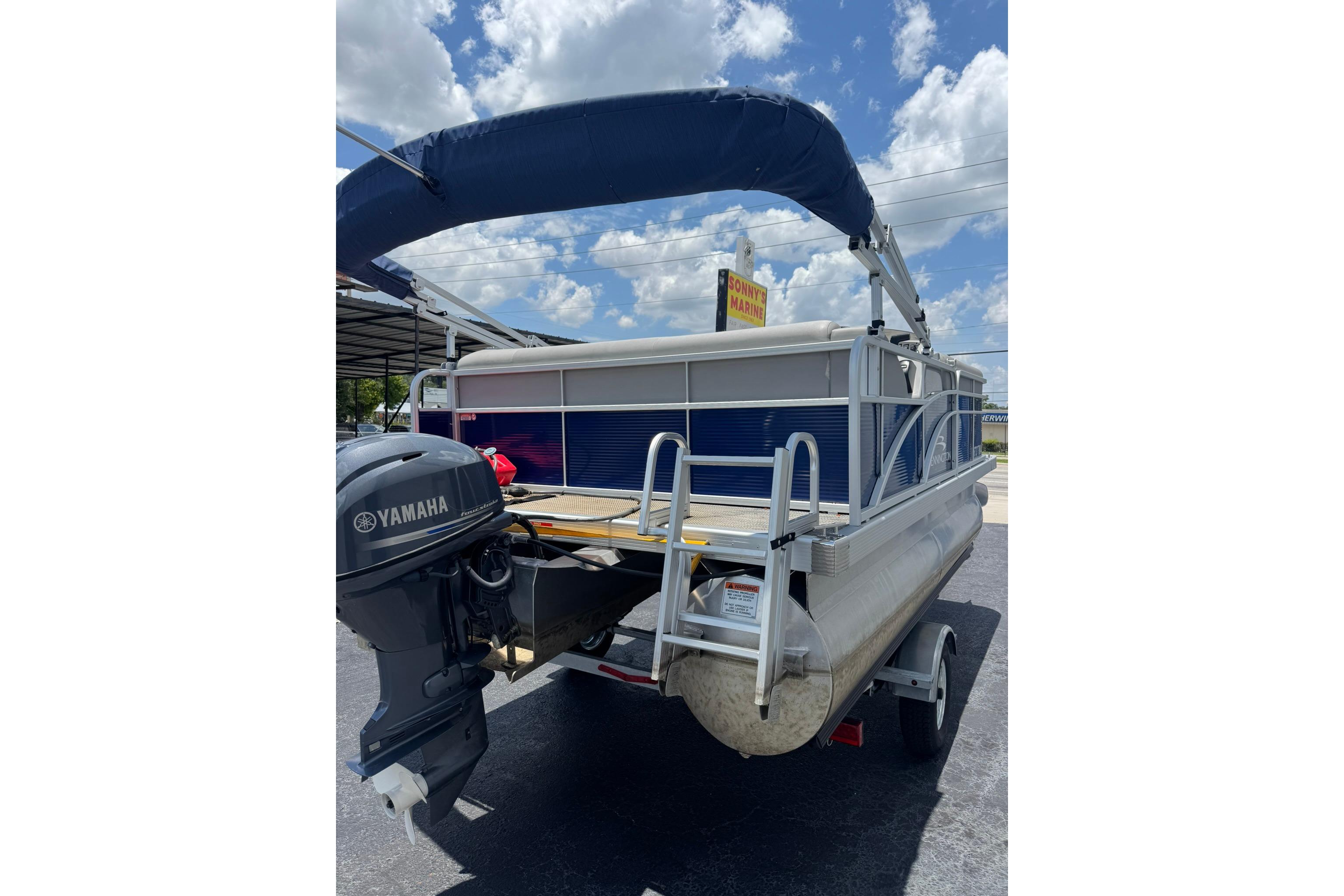 2024 Bennington SV 168 SLV pontoon boat with Yamaha motor, parked under a sunny sky.