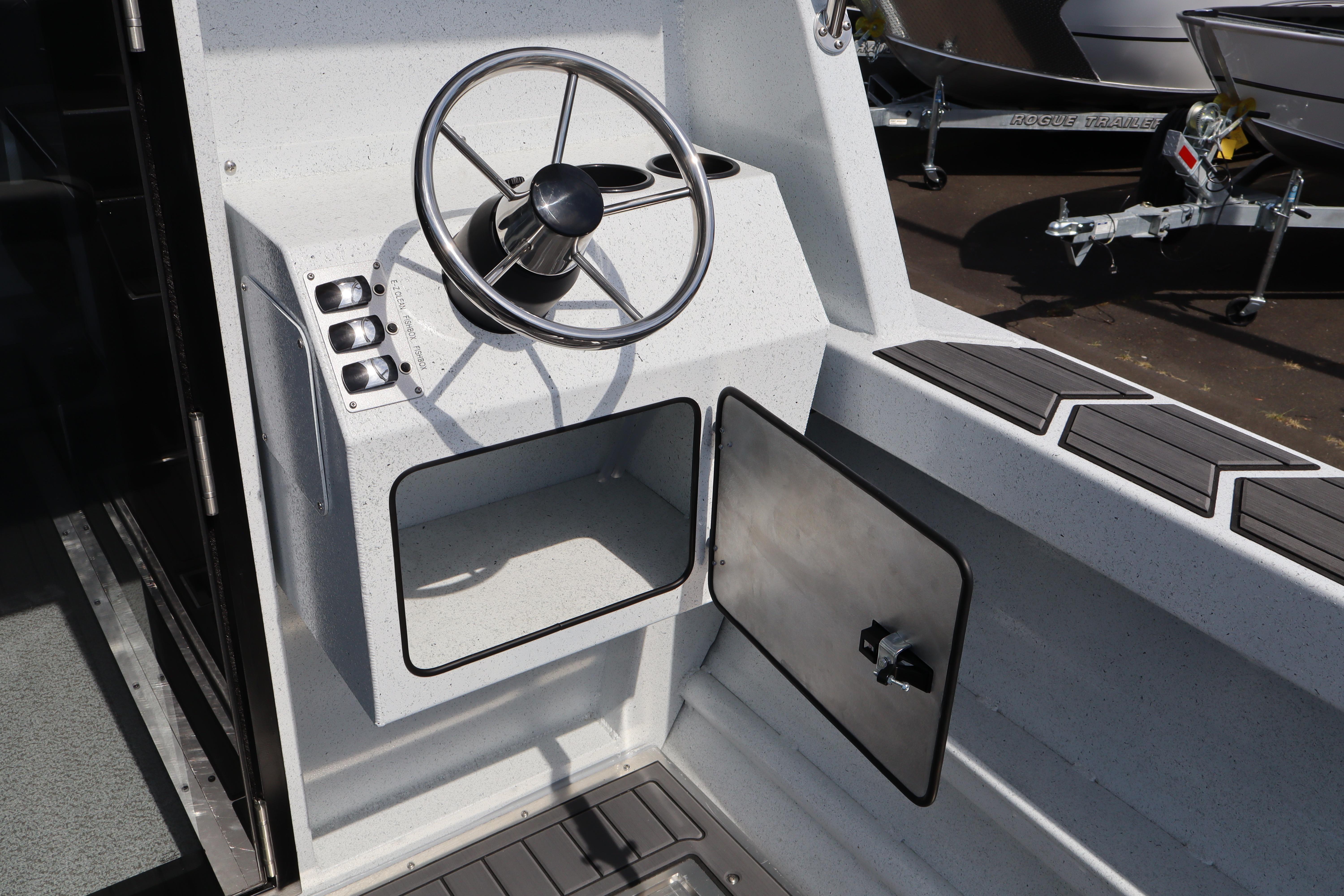 Steering console of 2026 KingFisher 25 XAC boat with modern controls and storage compartment.