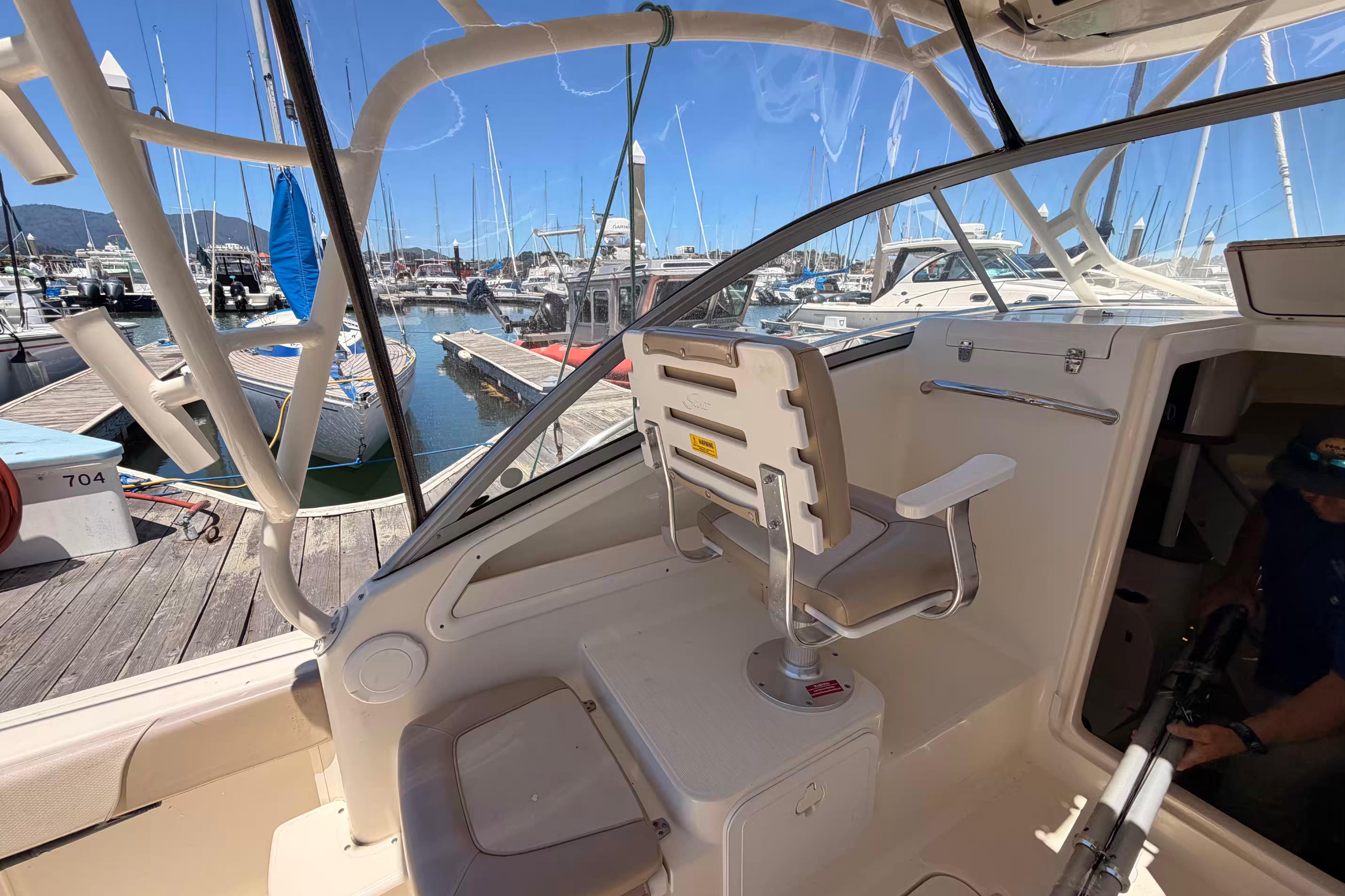 2007 Scout 262 Abaco boat interior at marina, featuring helm seat and dock view.