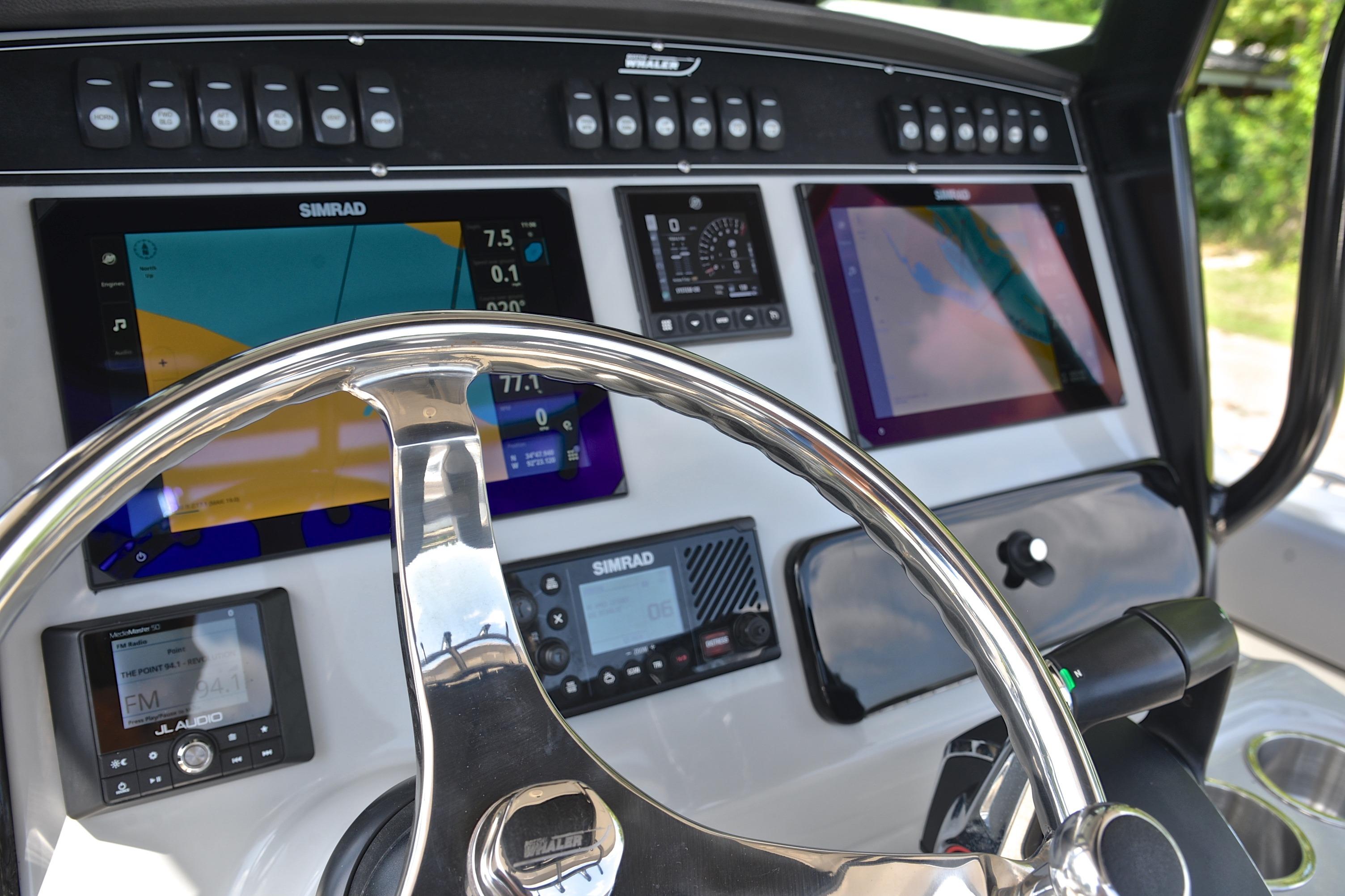 2024 Boston Whaler 250 Outrage dashboard with advanced Simrad navigation displays and controls.