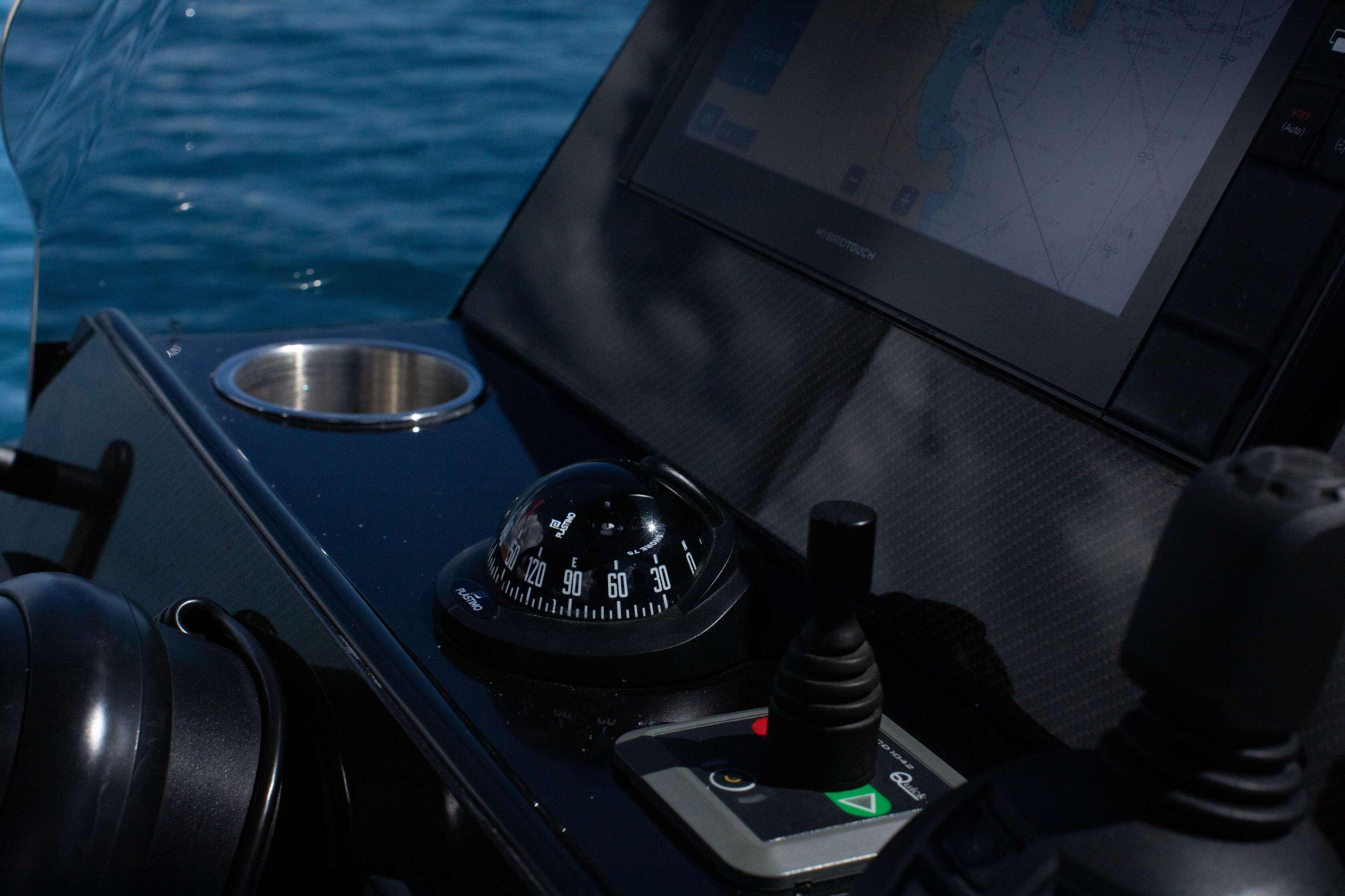 Control panel of 2021 Technohull Omega 47 boat with compass and navigation screen.