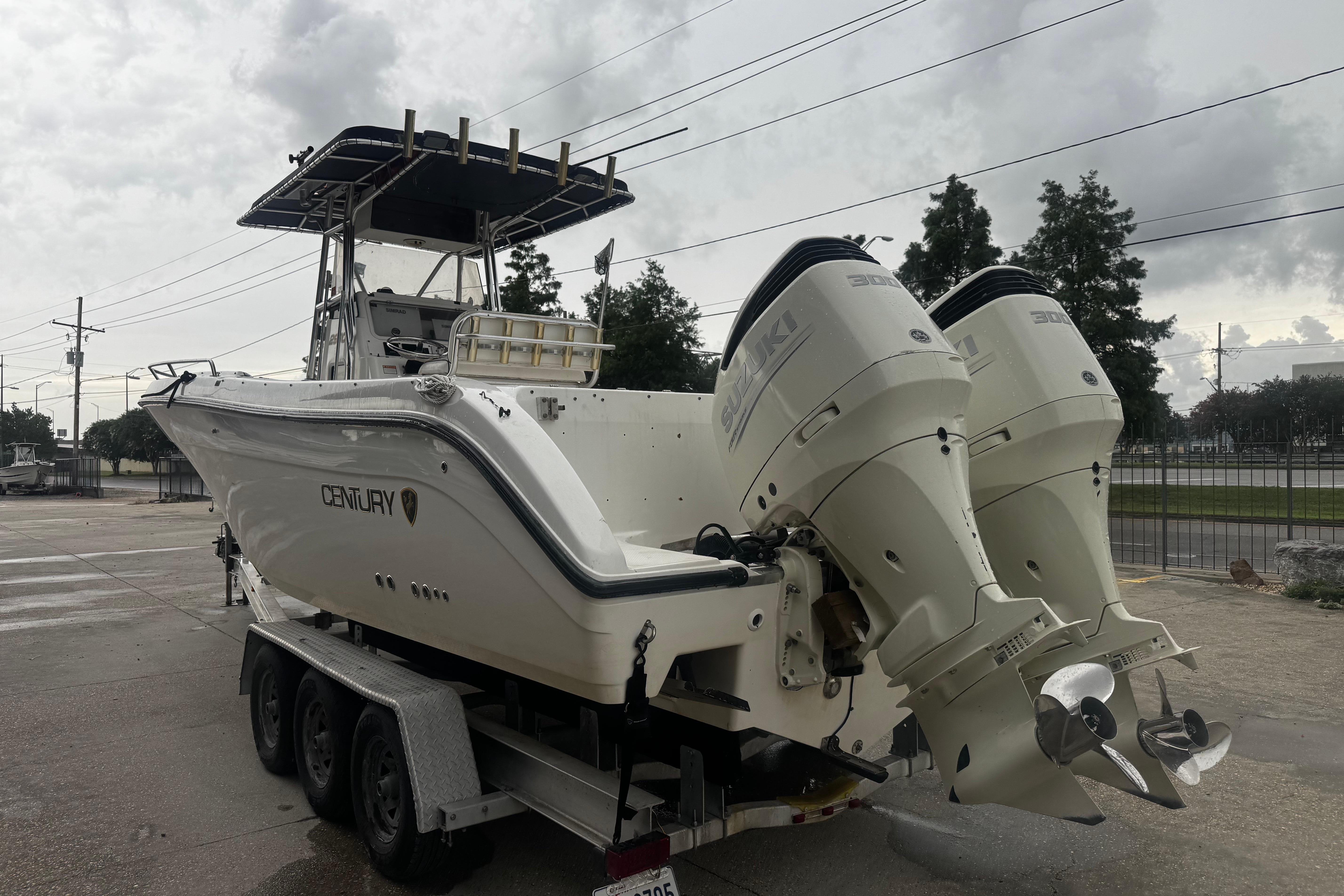 2004 Century 2900 Center Console boat with dual Suzuki engines on a trailer.