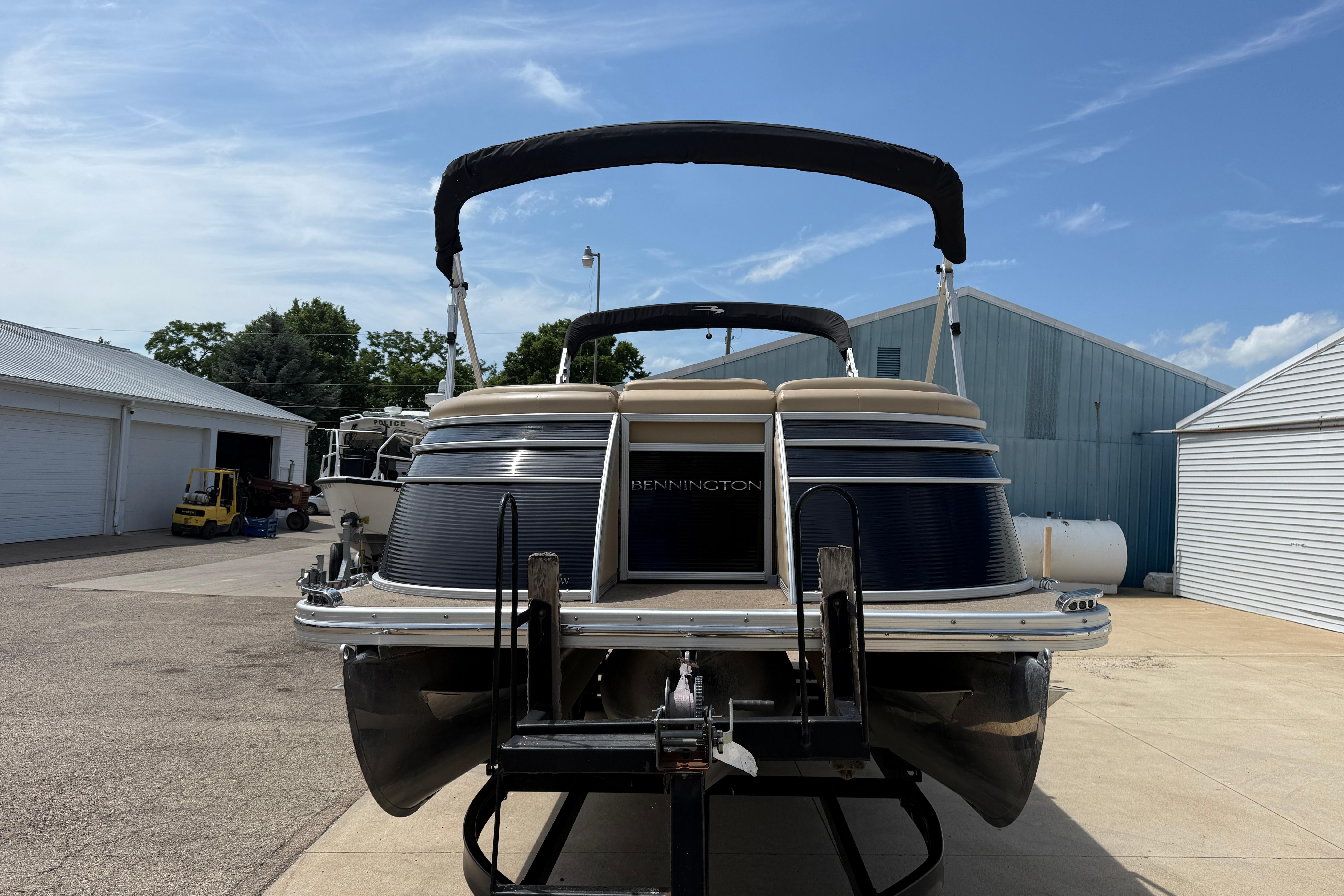 2011 Bennington 2575QCW I/O pontoon boat on trailer, parked outdoors.