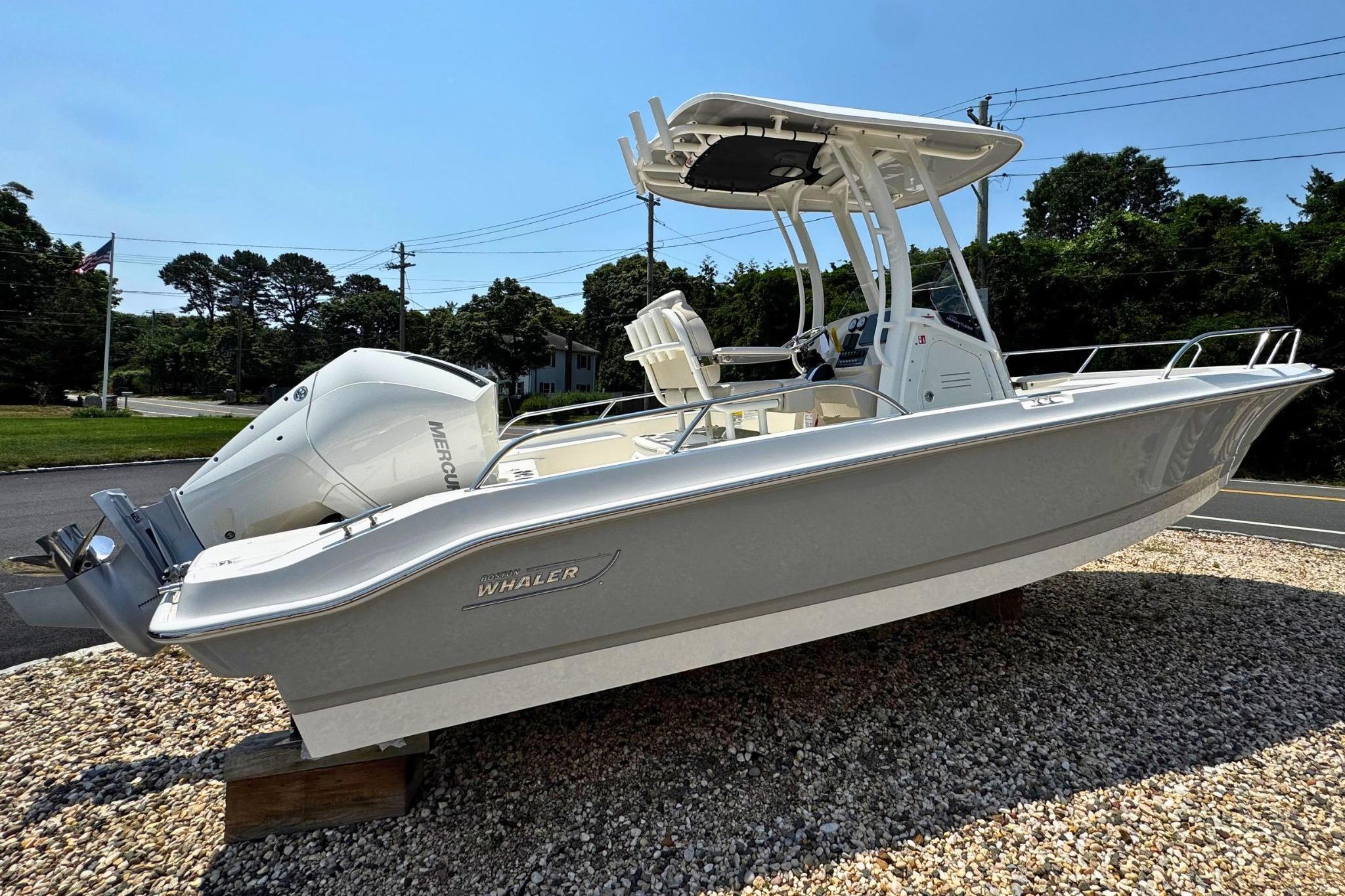 2026 Boston Whaler 220 Dauntless boat displayed outdoors on gravel.