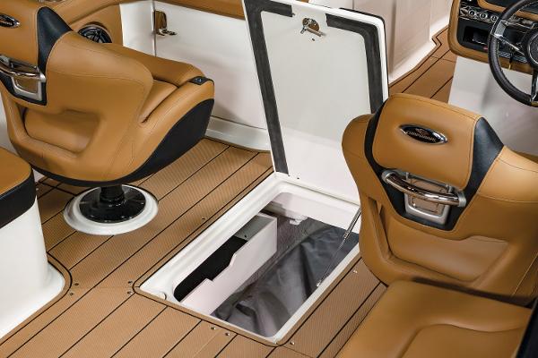 2024 Chaparral 28 Surf interior with tan seats and open storage compartment.