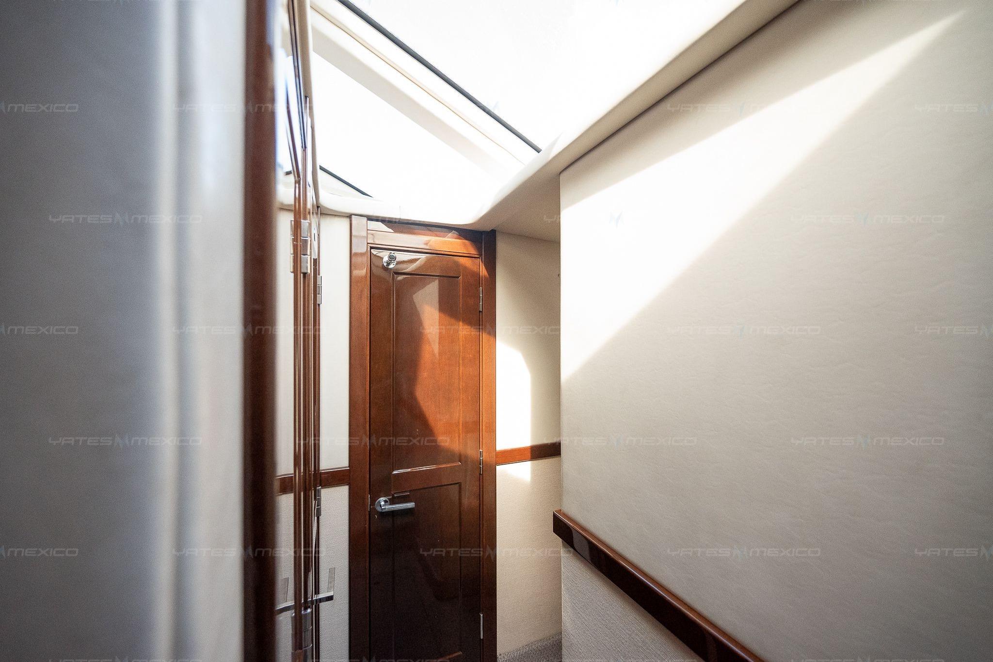 Interior hallway of 2008 Sea Ray 480 Sedan Bridge yacht with wooden door and skylight.