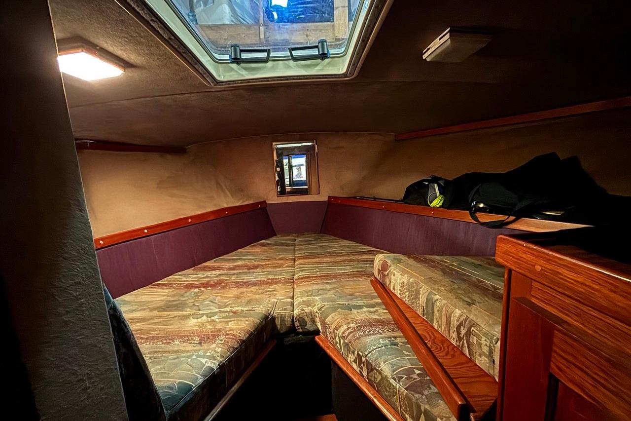Interior cabin of 1986 Trojan F-36 Convertible boat with cozy sleeping area.
