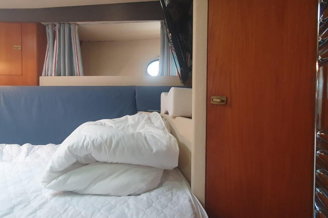 Cozy cabin interior of 1989 Princess 35 yacht with bed and wooden accents.