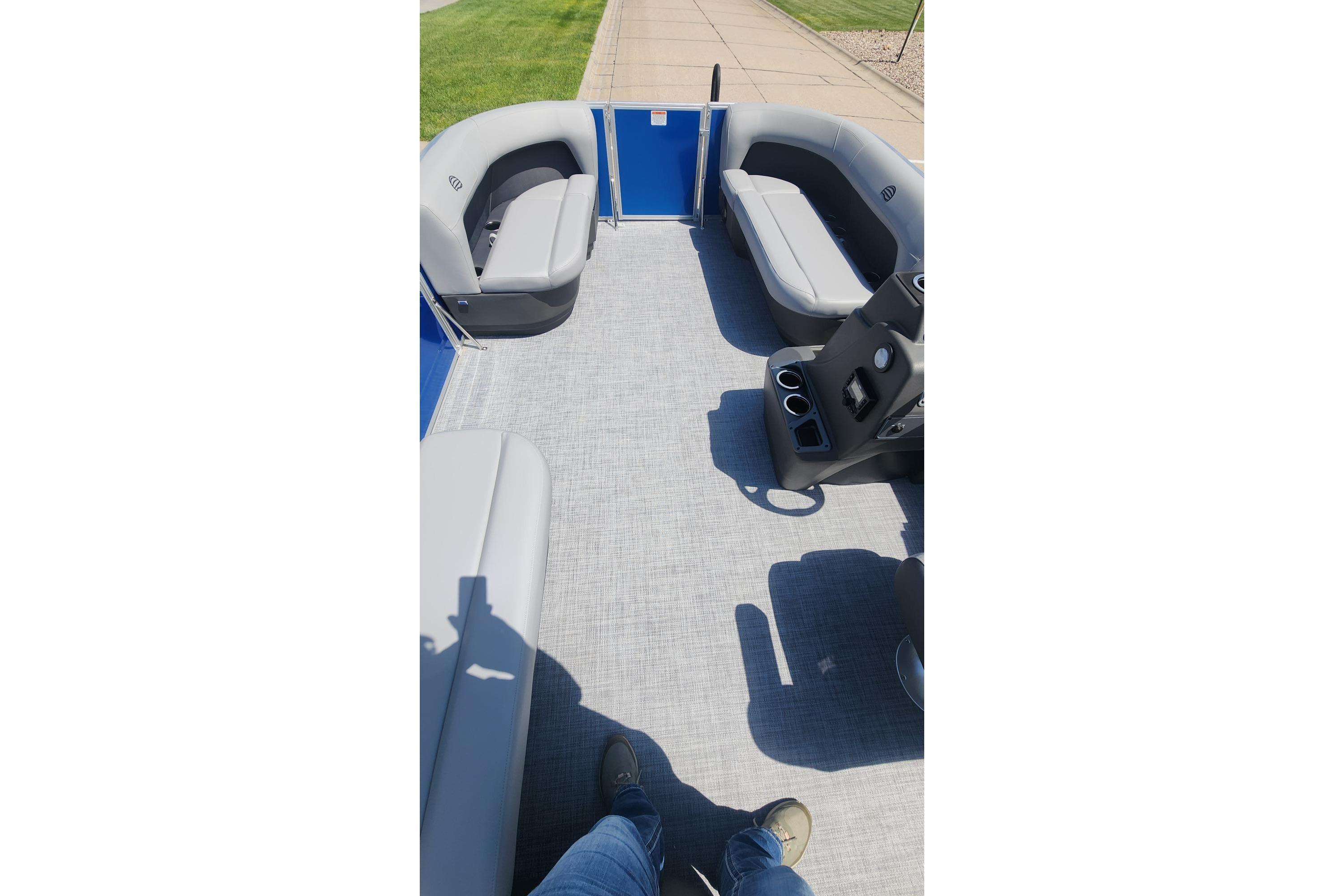 2026 Sun Tracker Party Barge 16 DLX interior with gray seating and control console.
