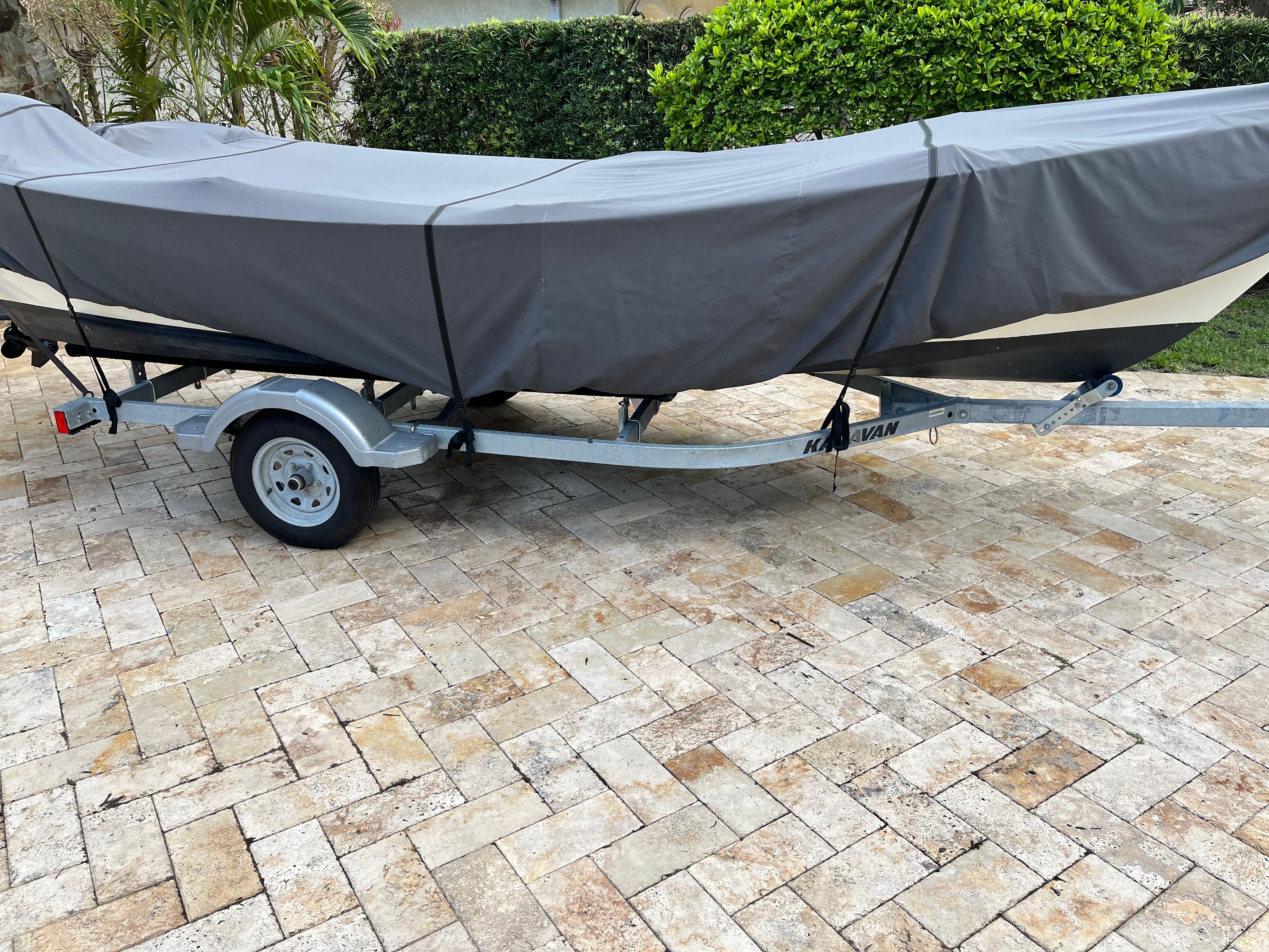 A 2021 Dory boat on a trailer, covered with a gray tarp.