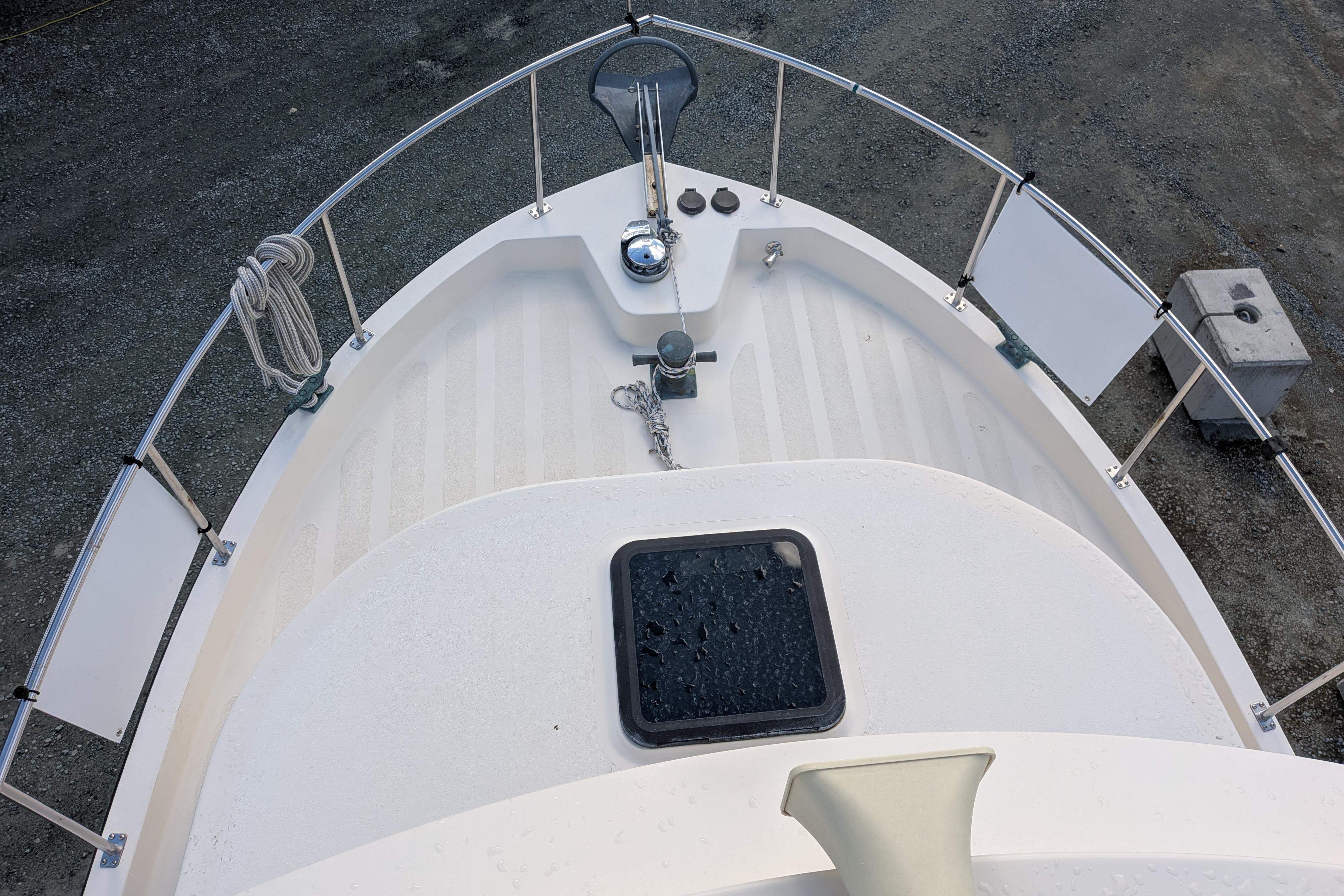 Bow view of a 1998 Nordic Tug 32, featuring deck details and railing.