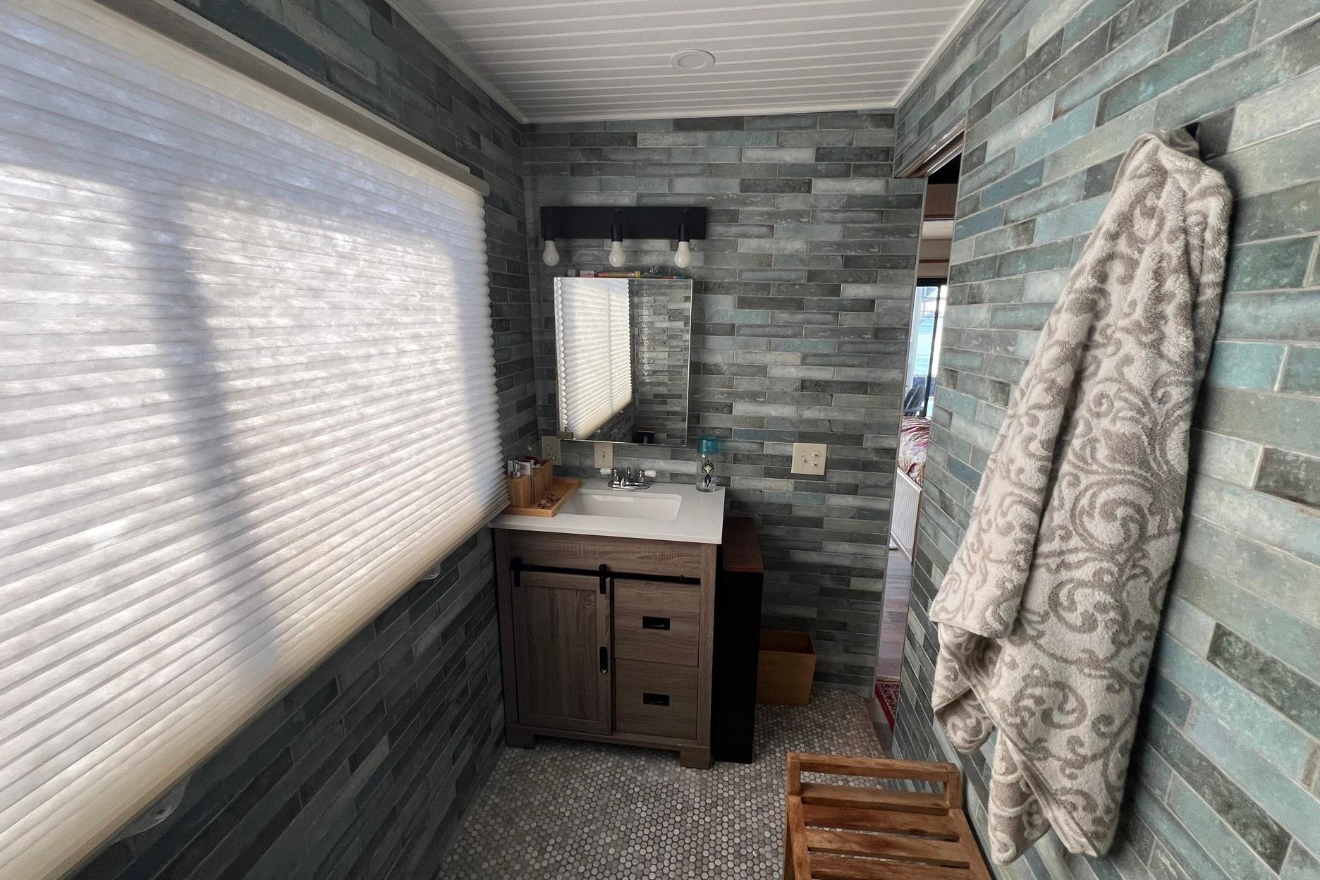 Bathroom interior of a 1993 Sumerset houseboat with modern vanity and textured walls.