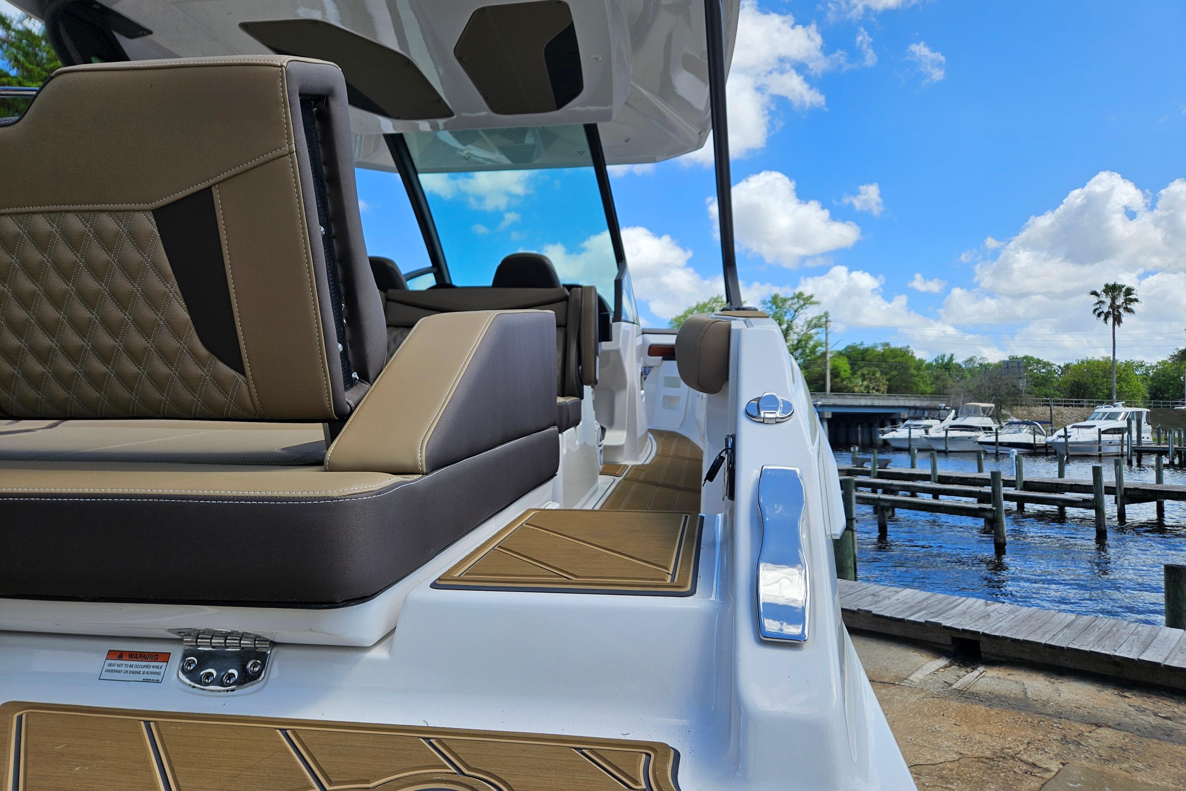 2026 Monterey Elite 30 OB boat interior with luxurious seating, docked by a scenic marina.