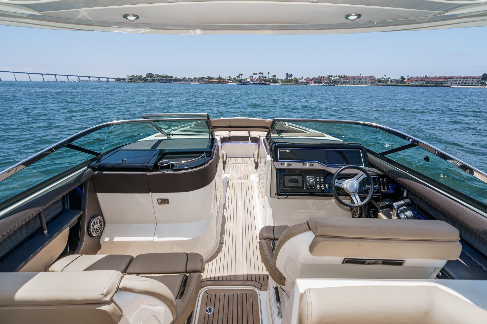 2018 Sea Ray SLX 310 boat interior with steering wheel, luxurious seating, and ocean view.