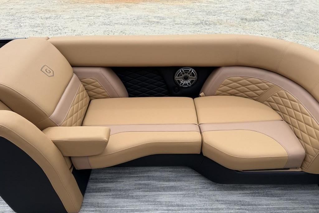 Luxurious tan seating on 2026 Godfrey Monaco 235 SFLC iMPACT boat, featuring quilted design and speaker.