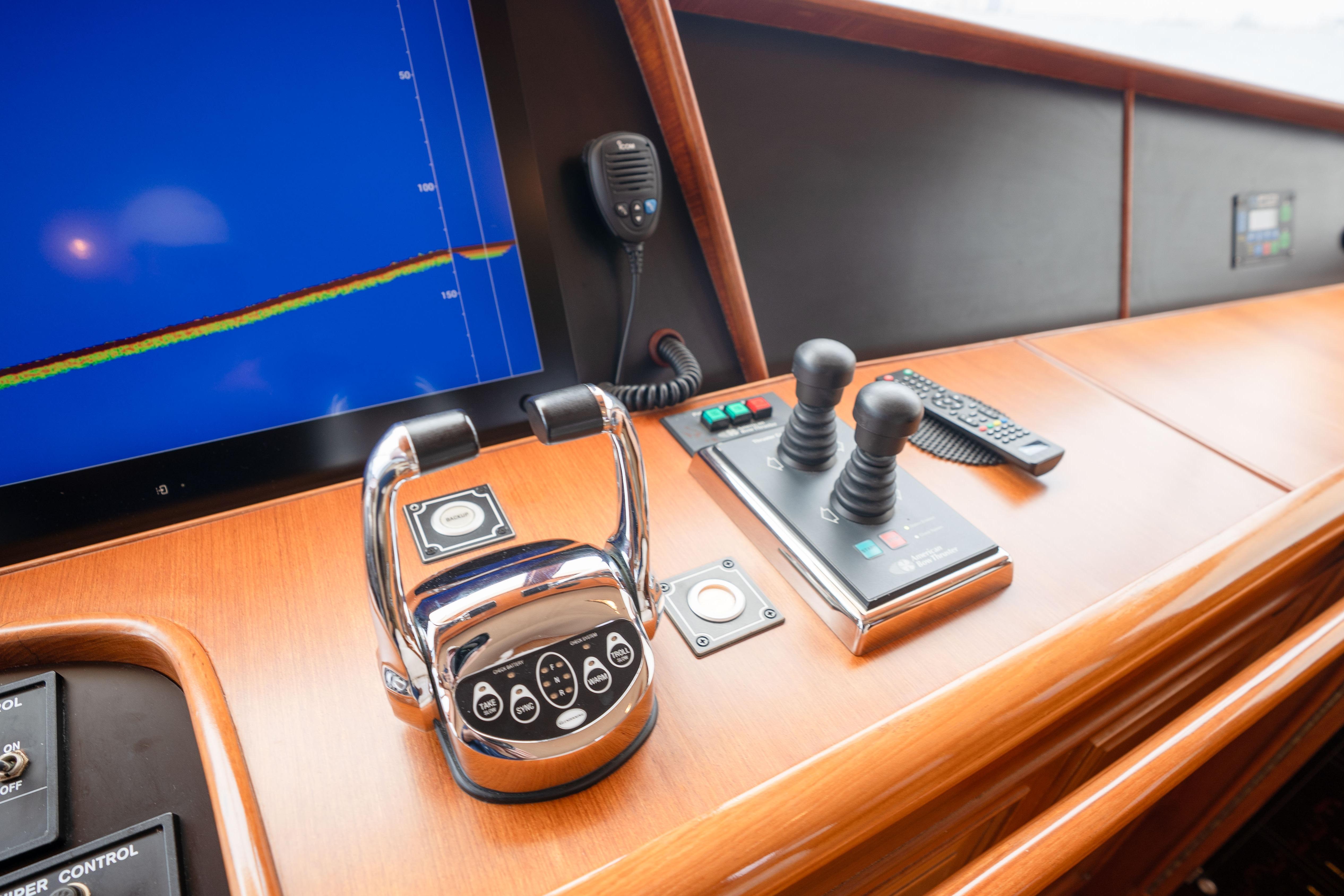 Control panel of a 2006 Fleming 75 yacht with navigation screen and throttle levers.