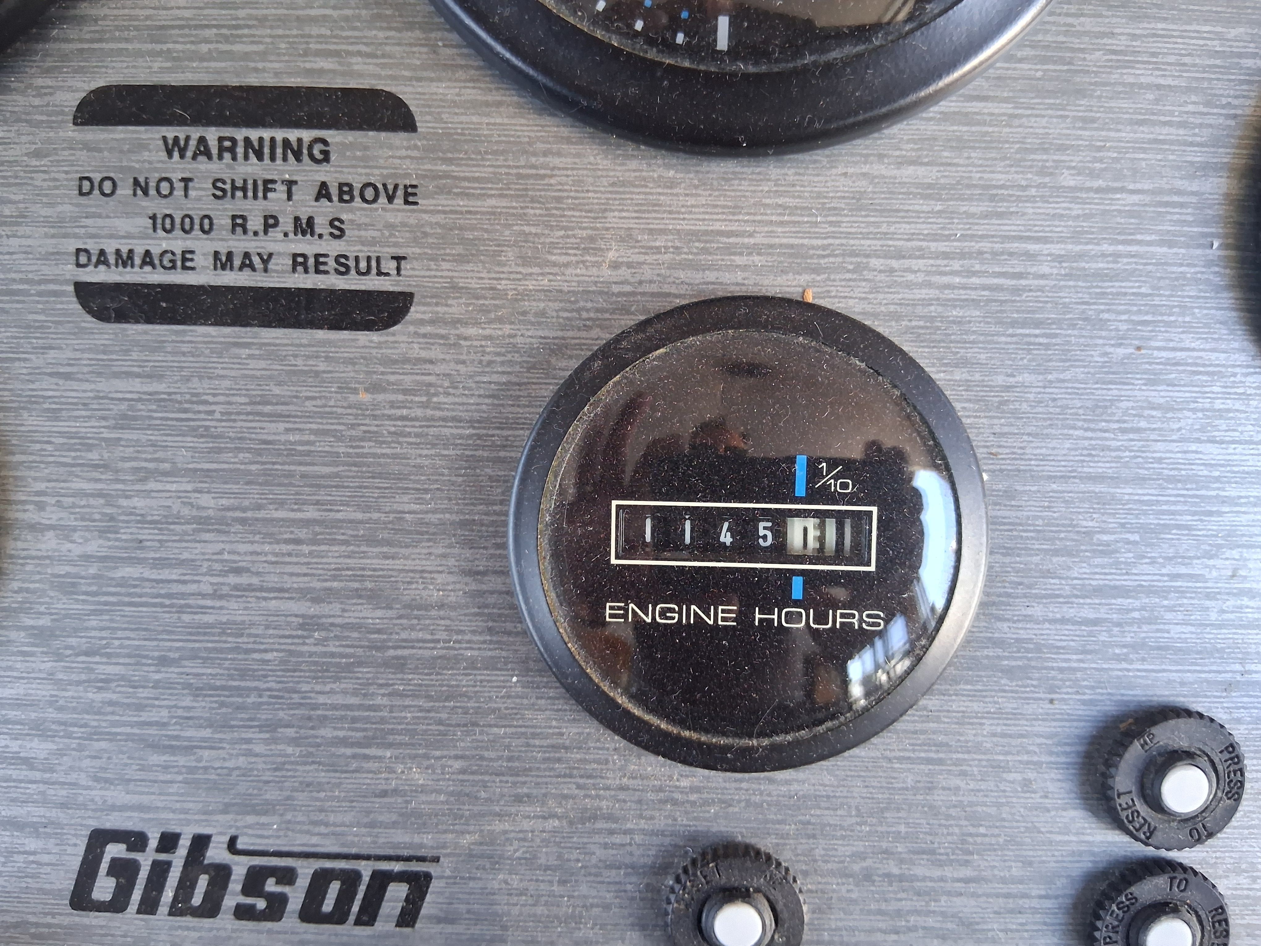 Close-up of an engine hour meter on a Gibson boat, displaying 1145 hours.